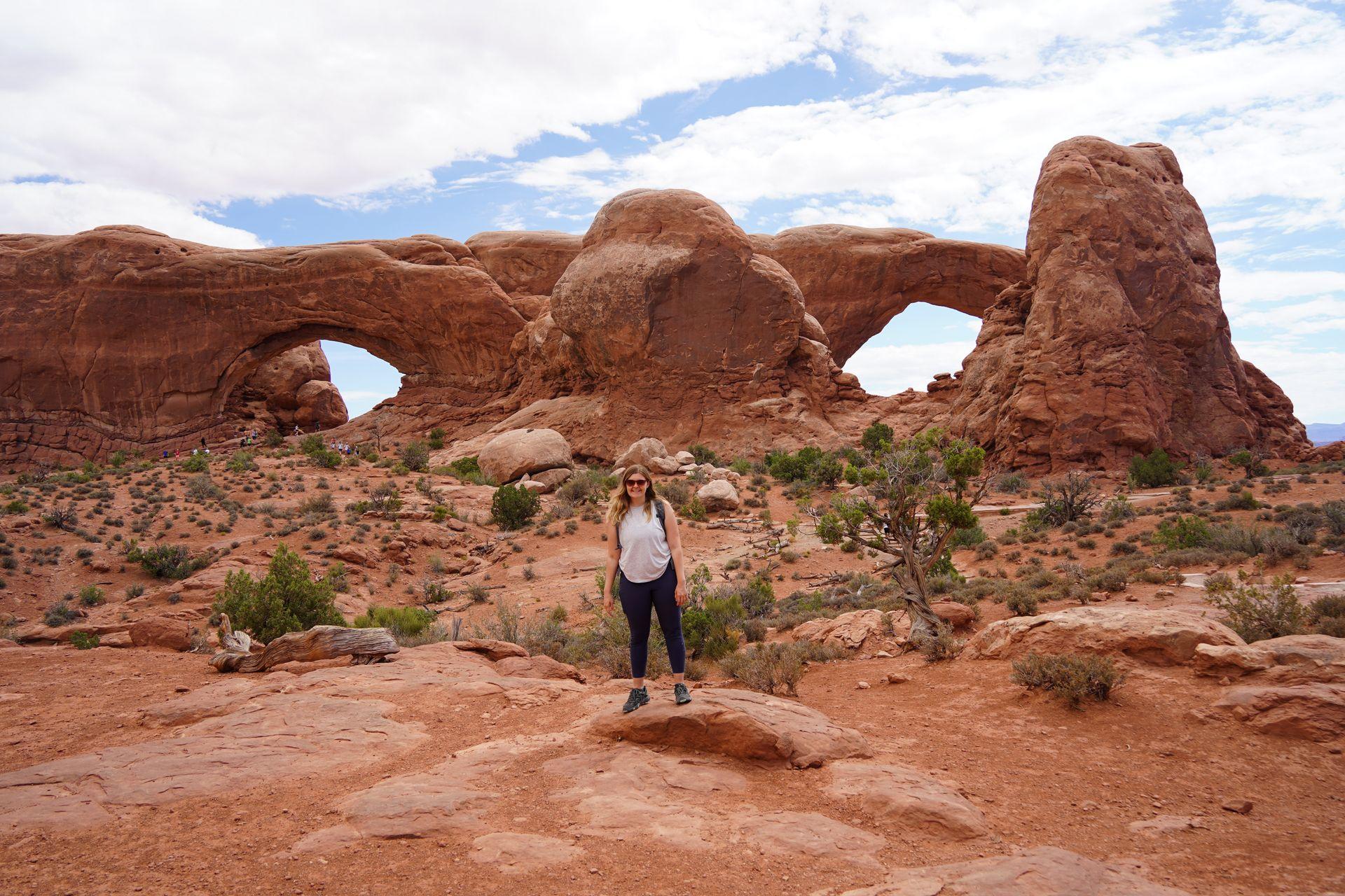 Lydia standing centered between the Windows, two giant arches that resemble the shape of eyes.