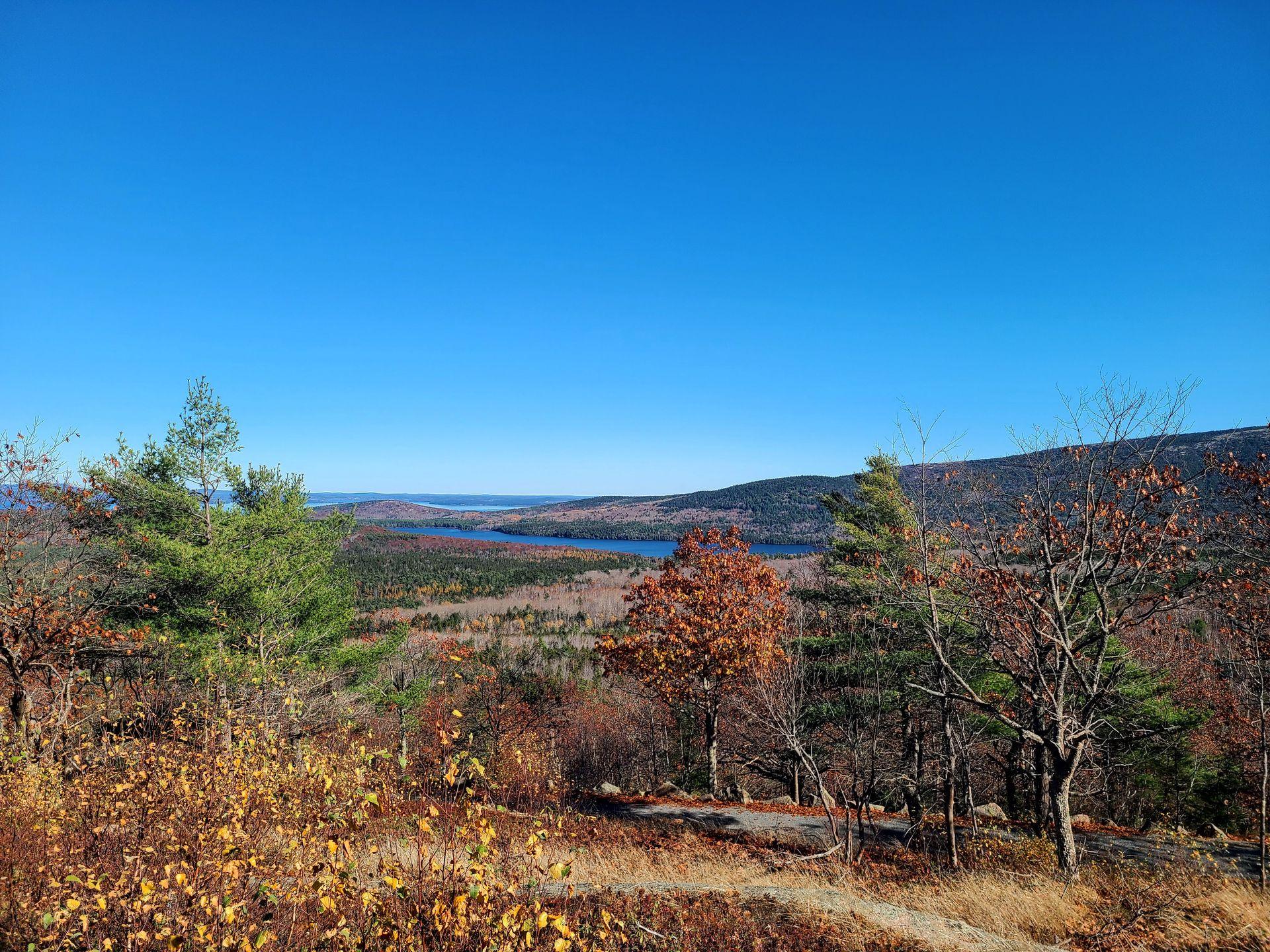Rolling hills and a lake seen from the Around the Mountain trail on the Carriage Roads in Acadia.