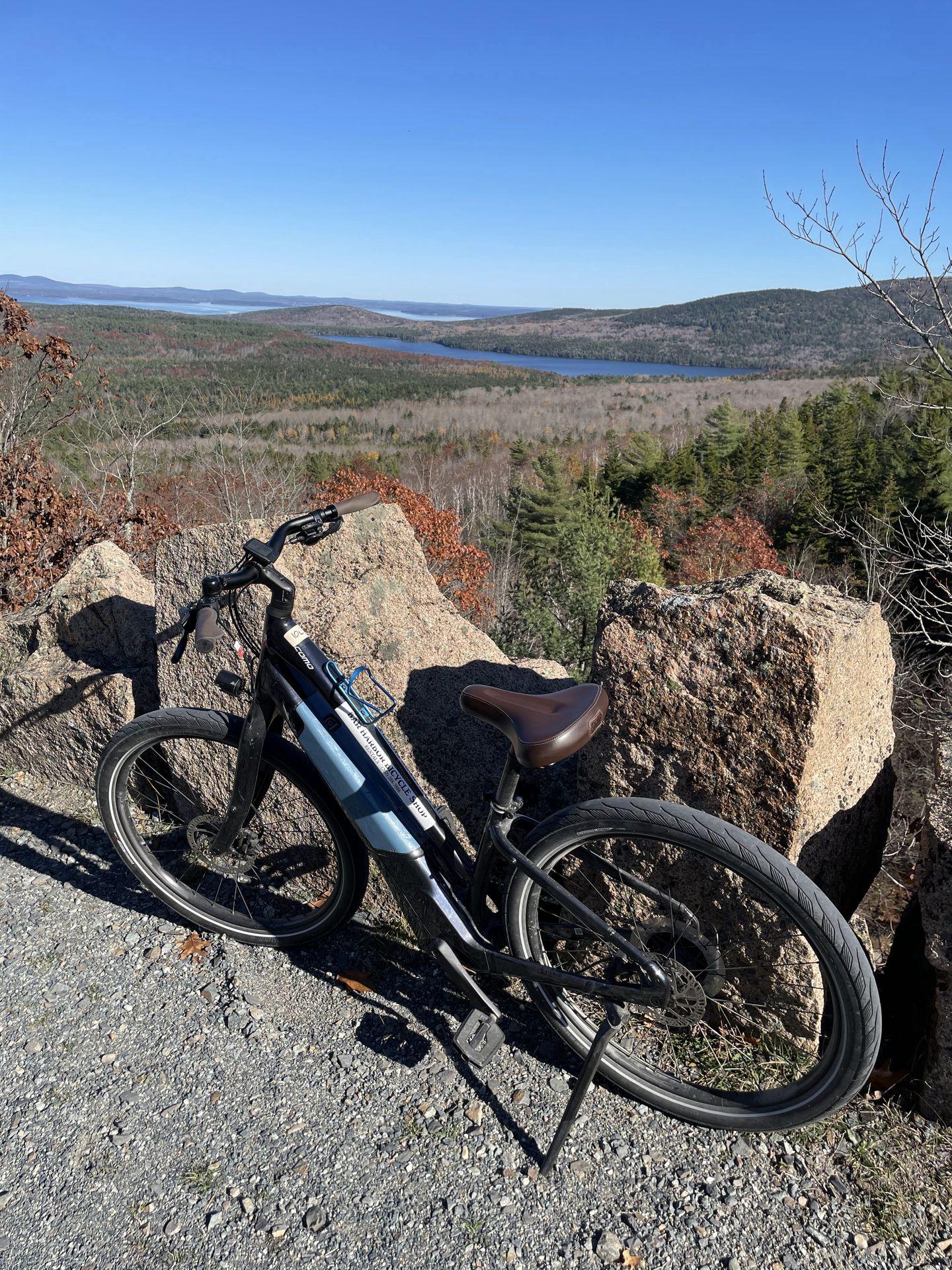 A e-bike on the Carriage Roads with a view of a lake behind it.