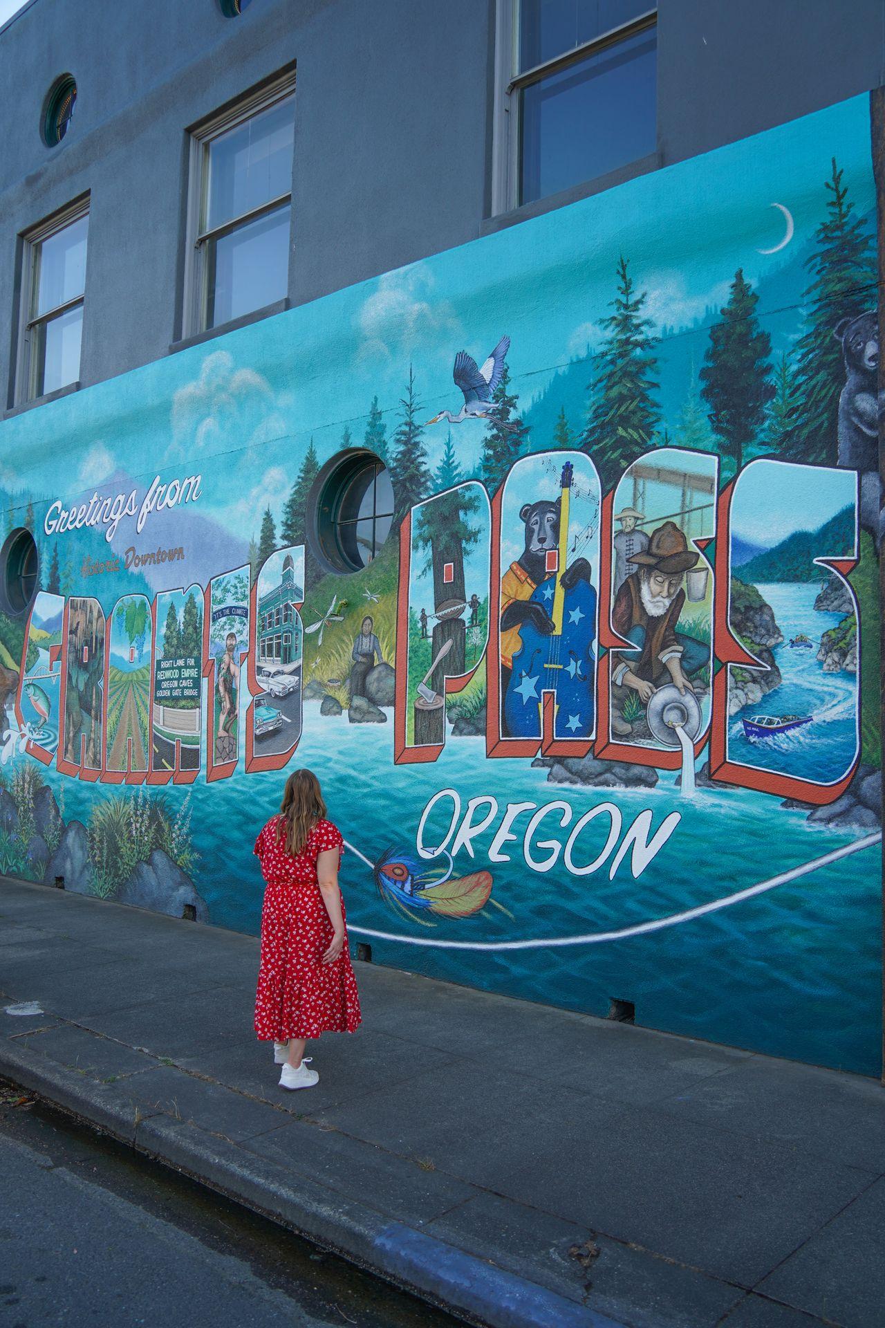 A colorful mural that reads 'Greetings from Grants Pass' with different elements inside of each letter