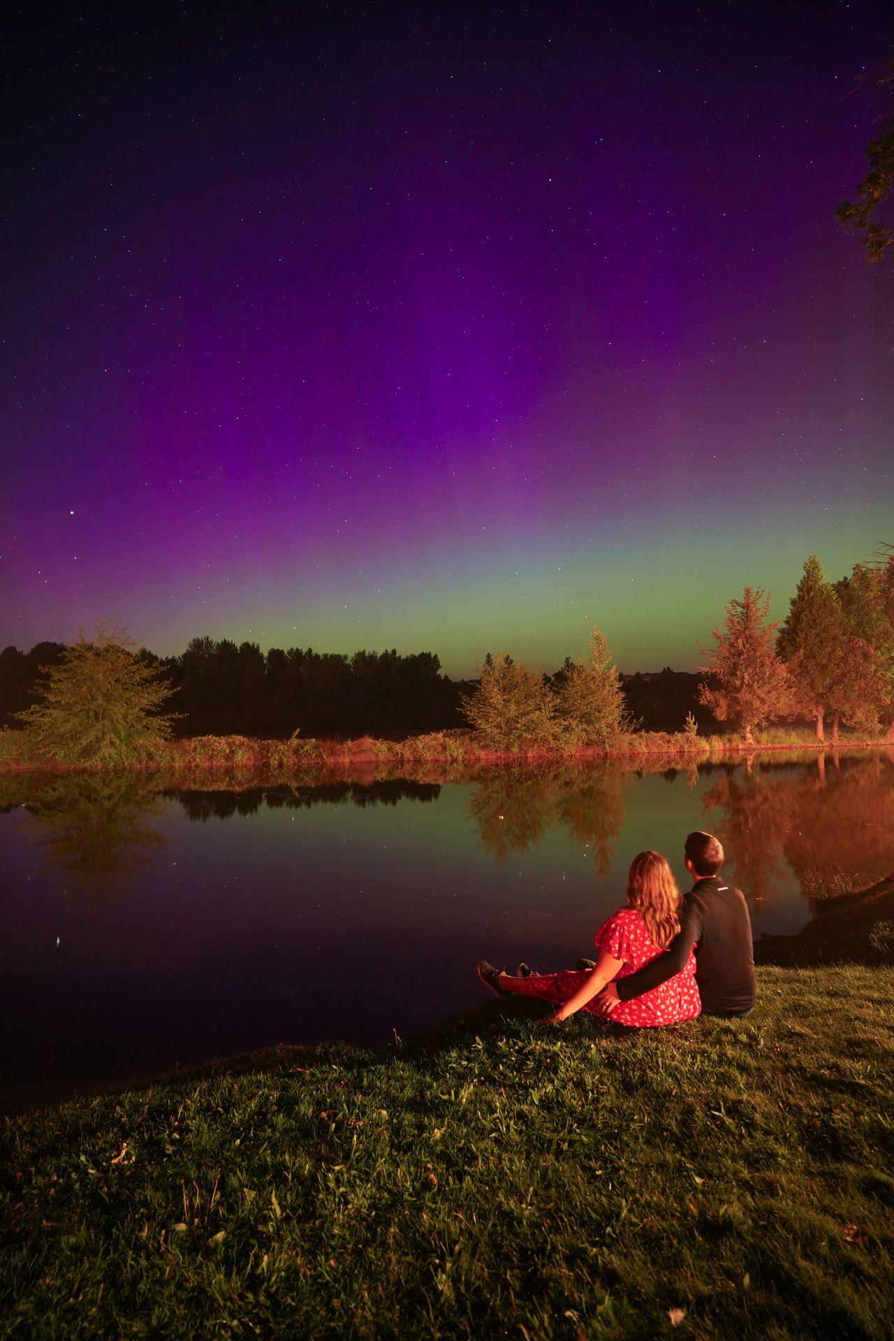 Lydia and Joe sitting and admiring the Northern Lights at Bridgeview Winery