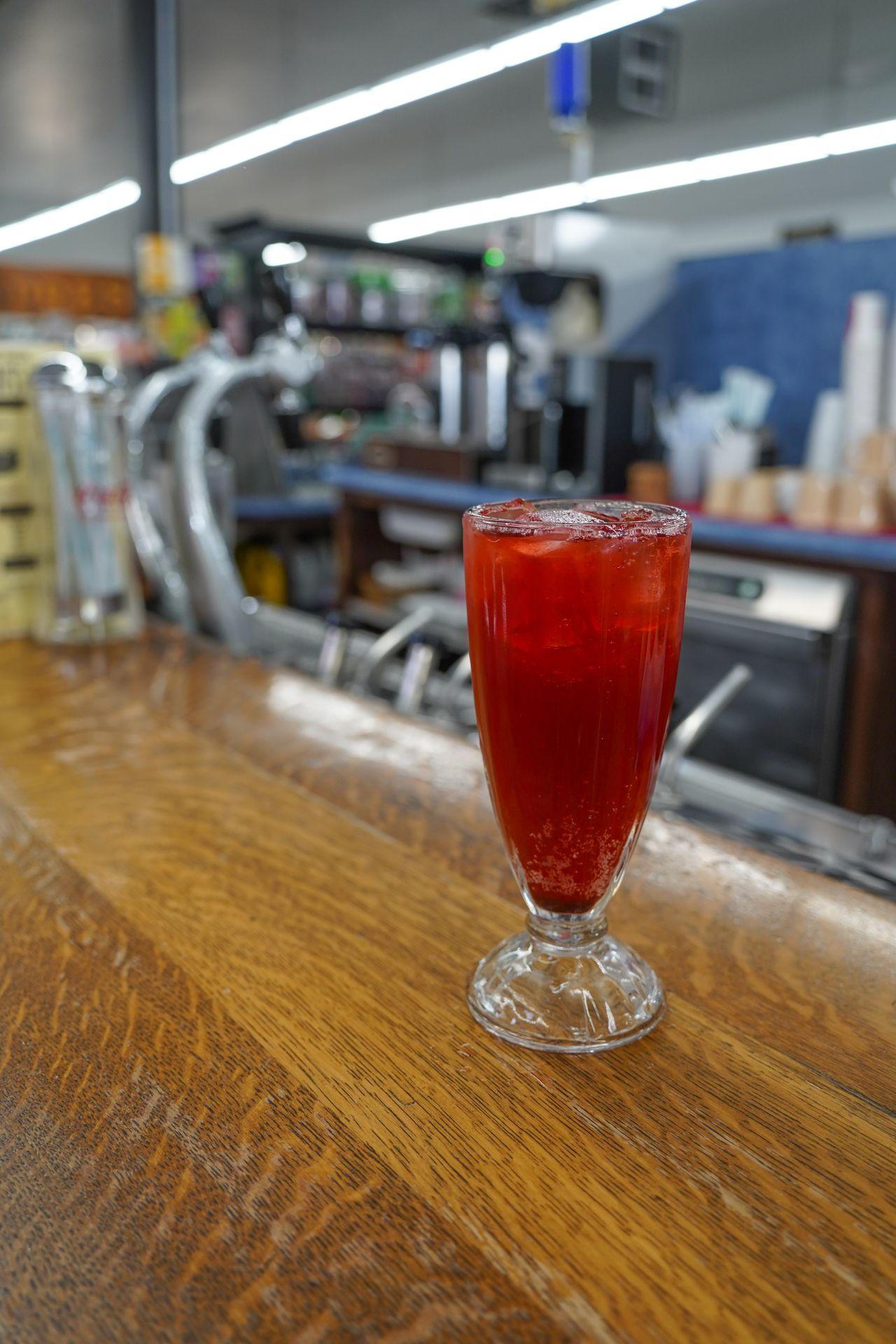 A red soda sitting on the bar inside Grants Pass Pharmacy and Soda Shop
