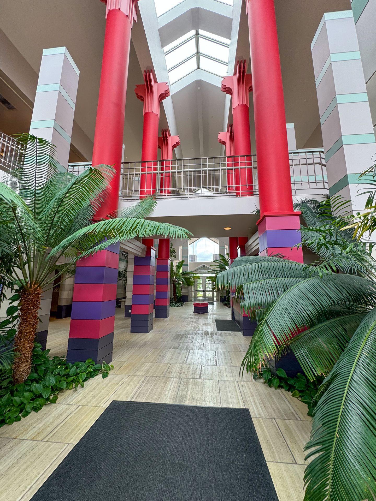 The lobby of the Cedar Rapids Museum of Art with colorful columns and large green plants.