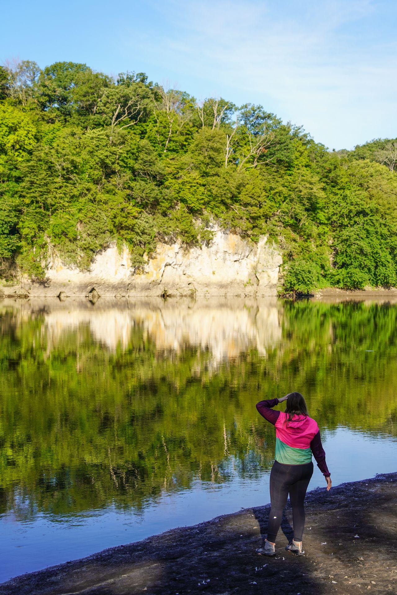 Lydia looking out at the river with a reflection in the water.