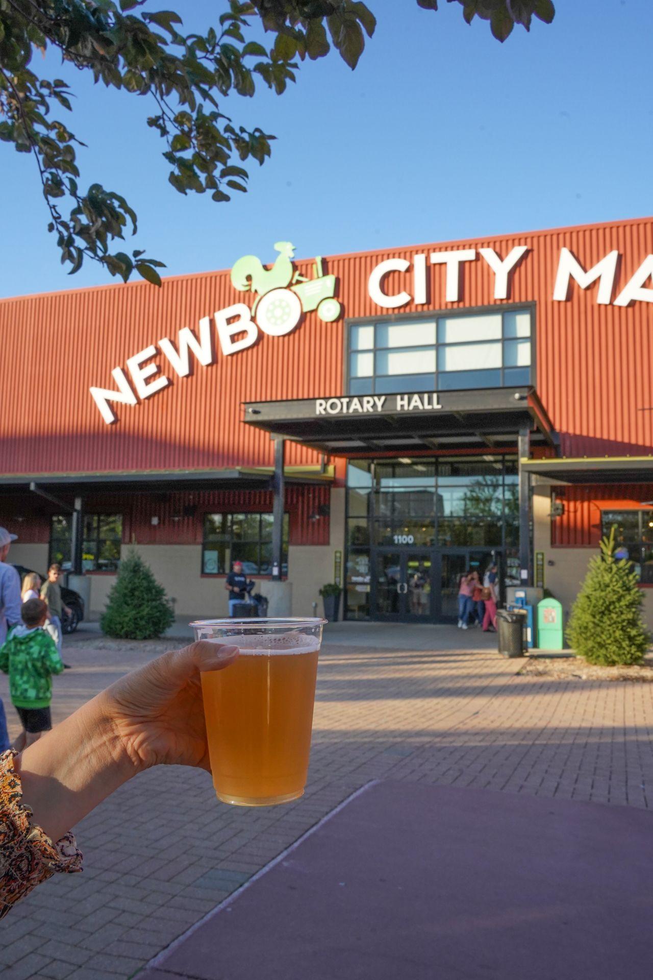 Holding up a beer in front of the NewBo City Market