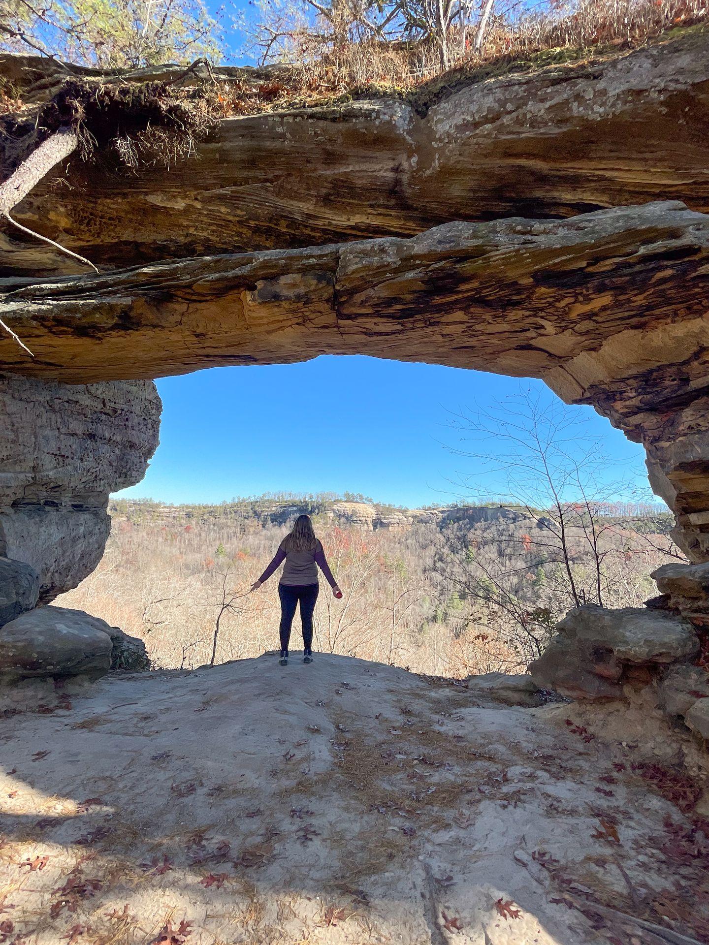 Lydia standing inside of an arch on the Double Arch Trail in Red River Gorge