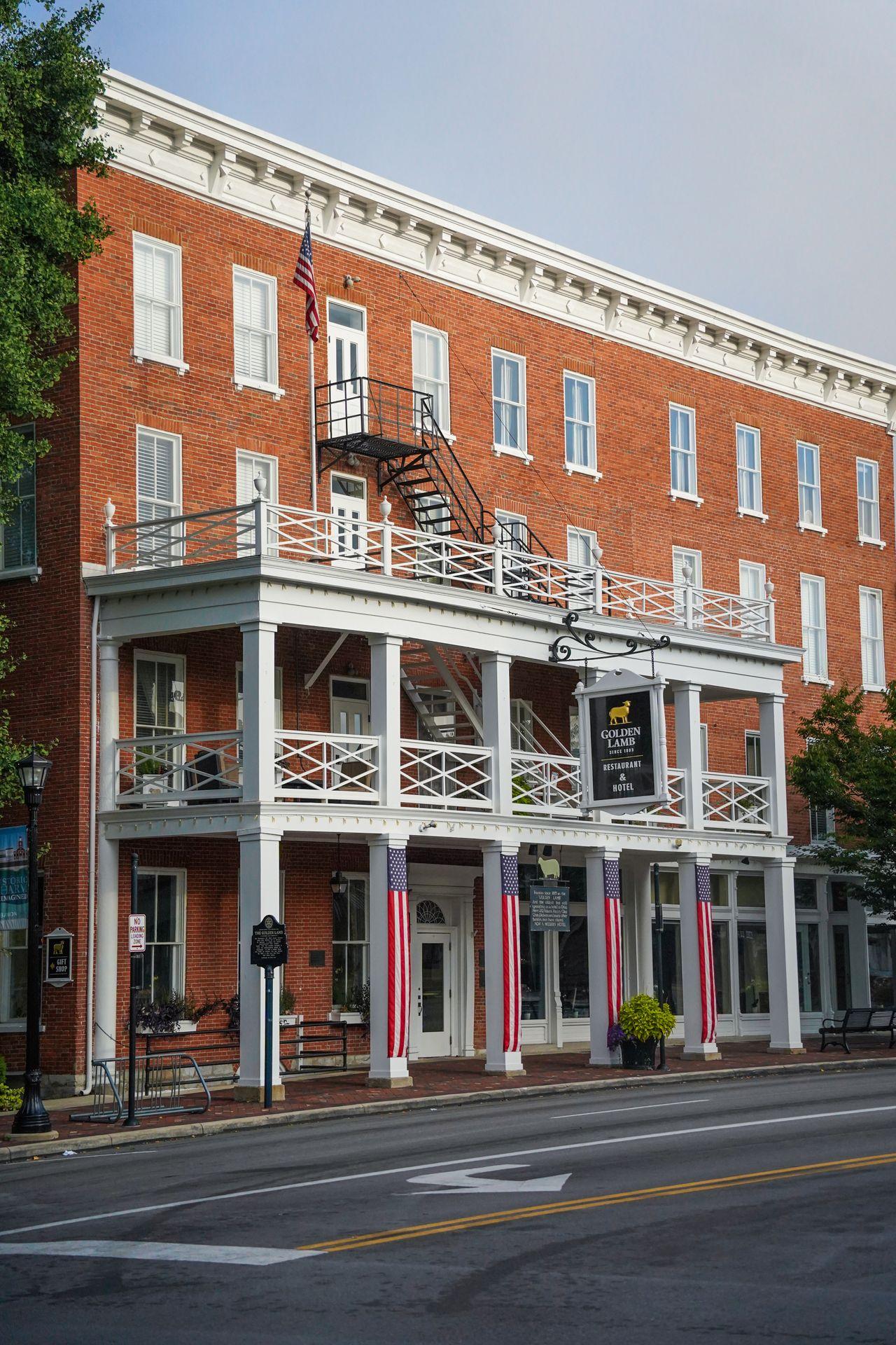 The exterior of The Golden Lamb Restaurant, which features white columns in front of a brick building