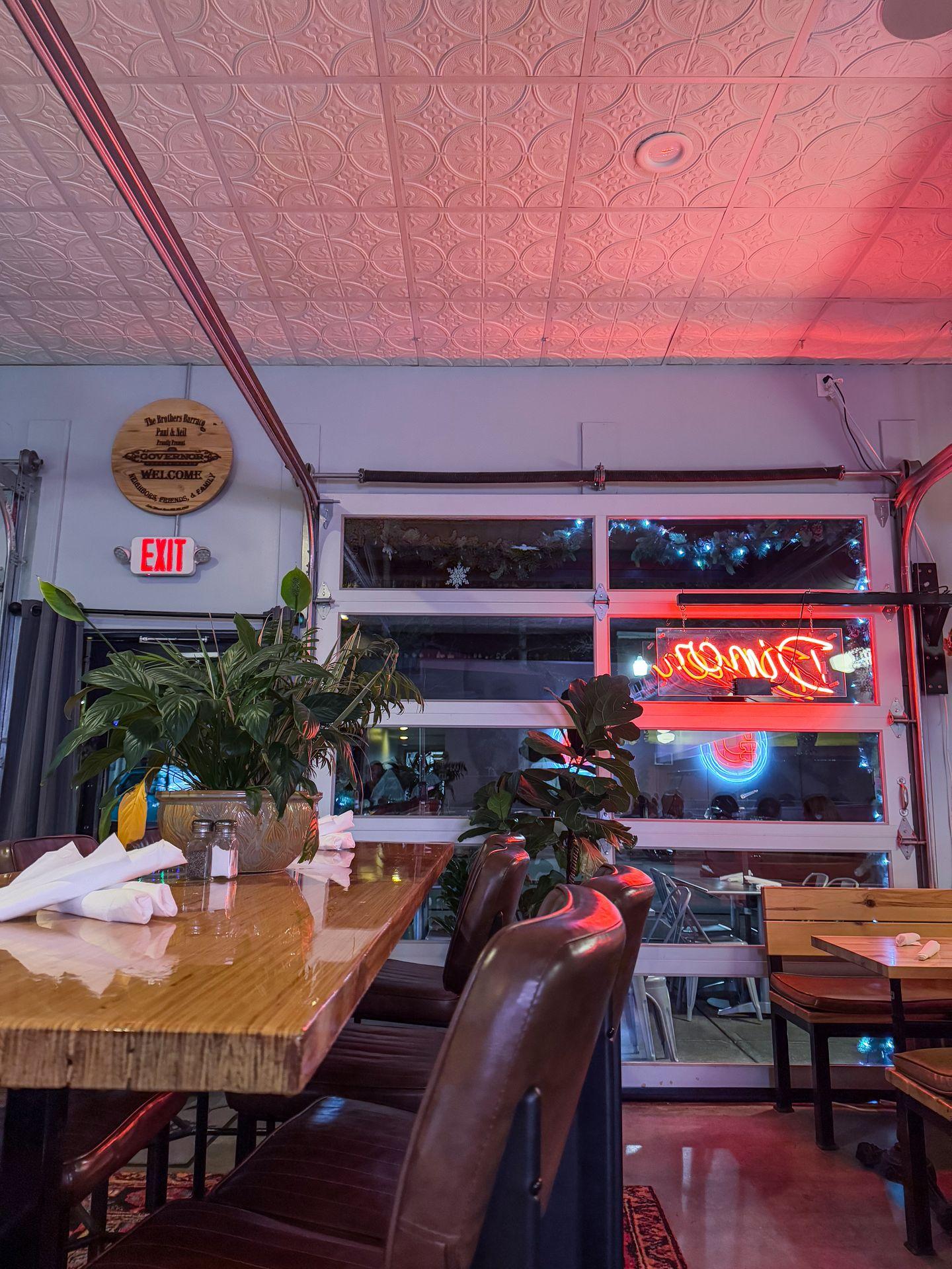 The interior of The Governor restaurant. There is a red neon sign on the window that reads 'Diner'