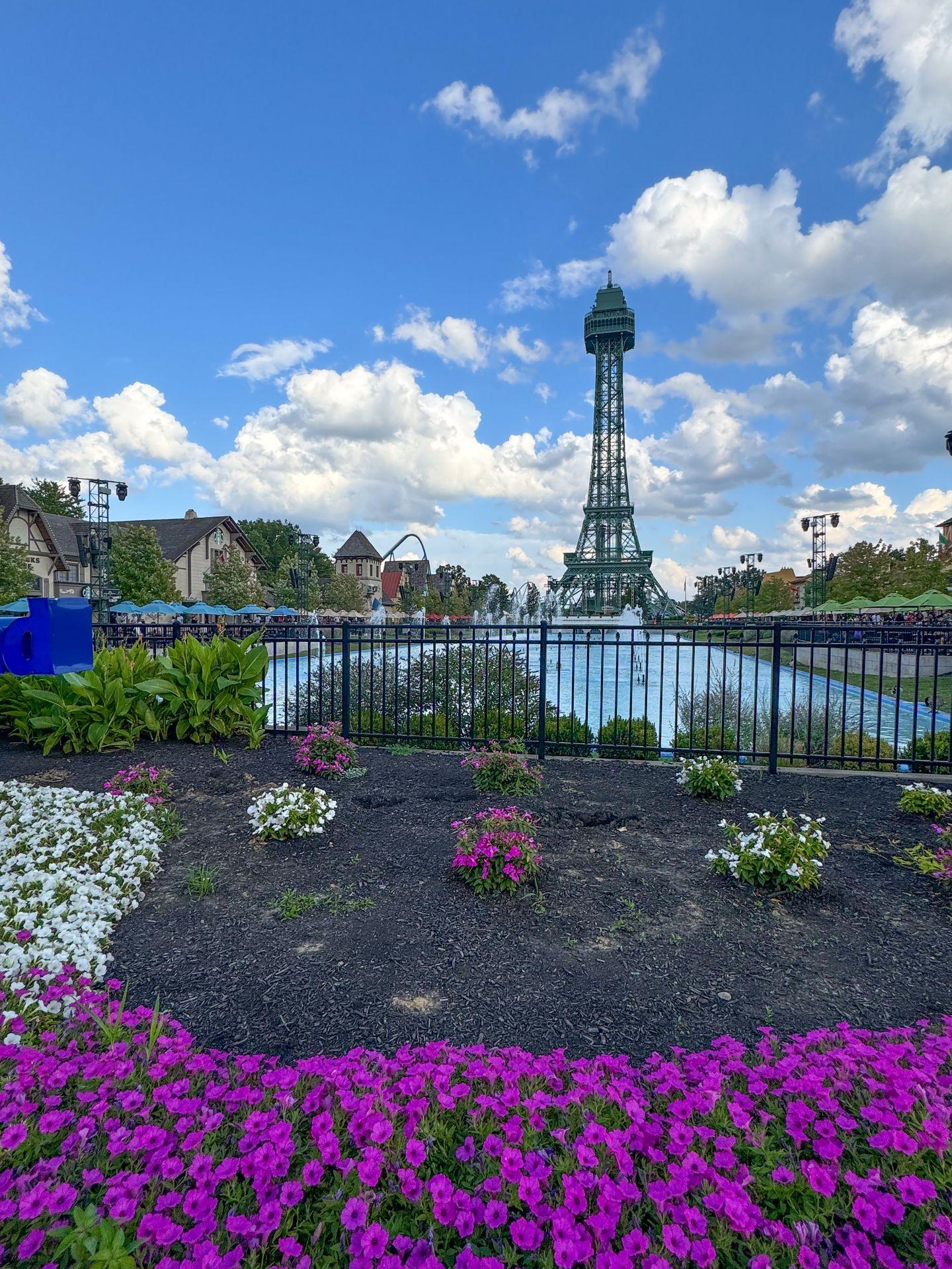 An eiffel tower in front of a blue pool of water at Kings Island Amusement Park