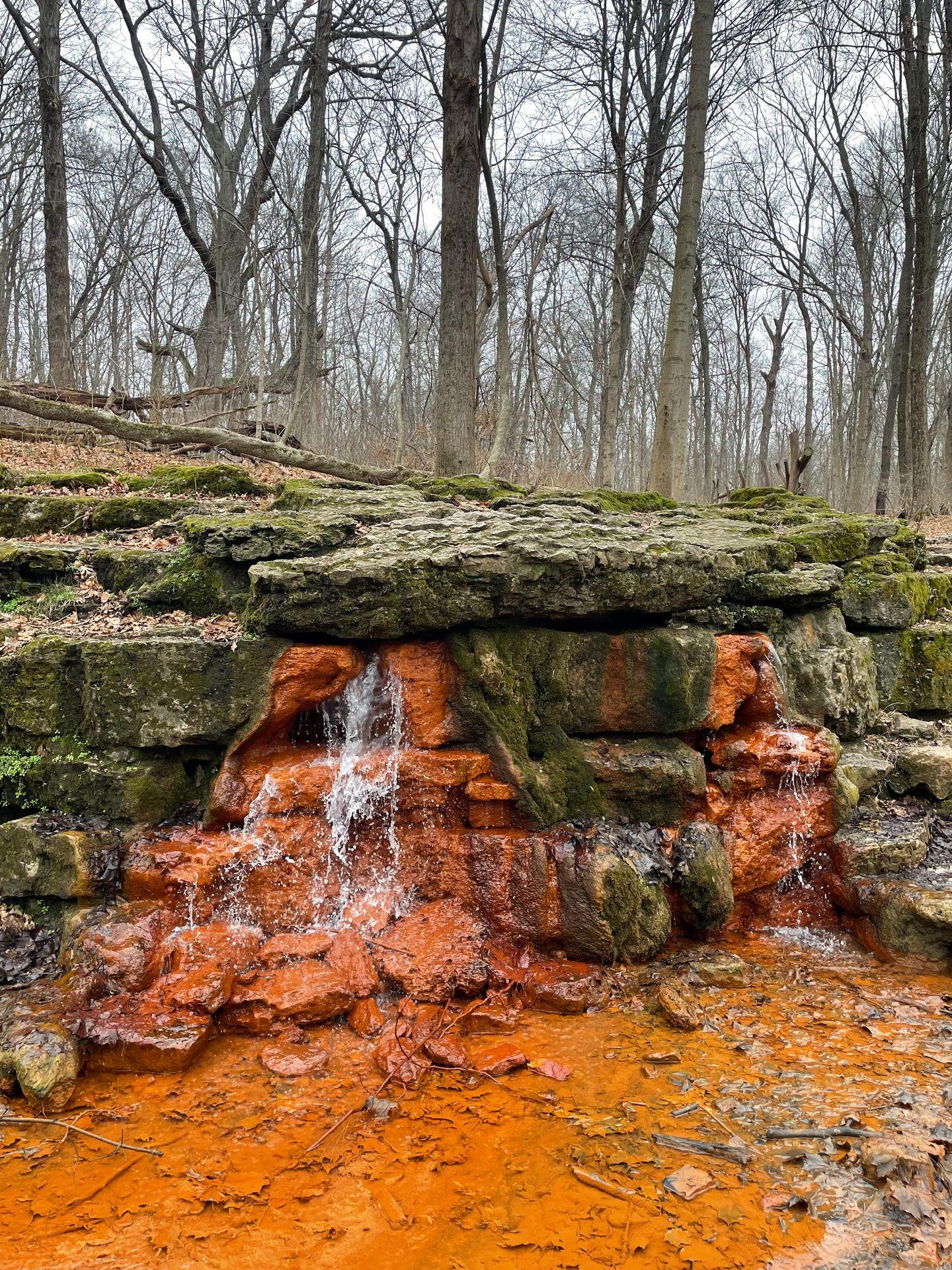 Water cascading down orange and green rocks in Glen Helen Nature Preserve