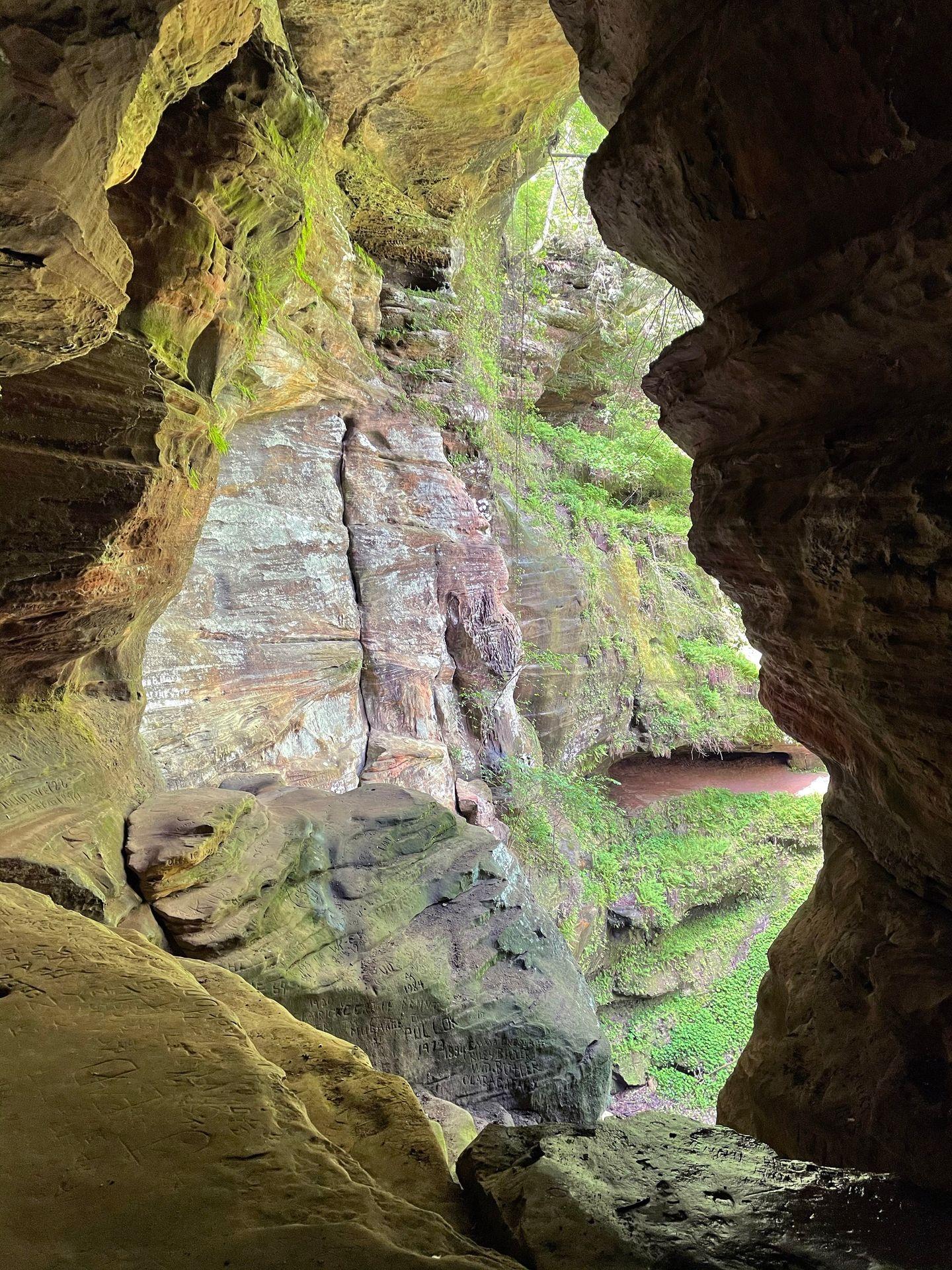 Looking out at moss-covered rocks inside of Rock House.