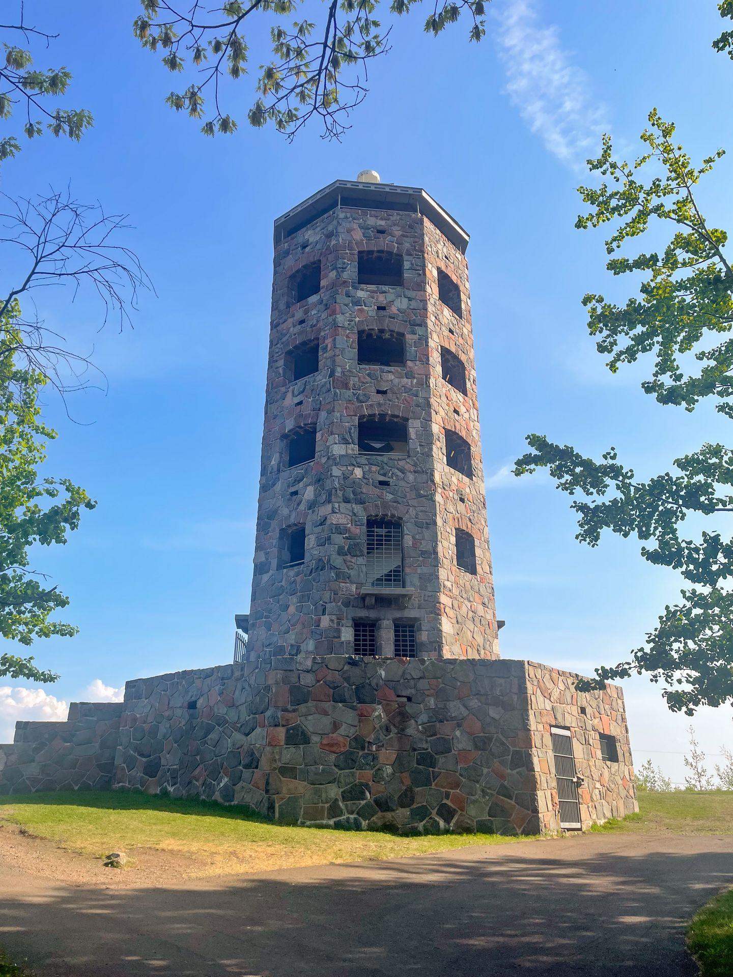 Enger Tower, which is made of brown stones. There are 4 levels of windows before reaching the top.