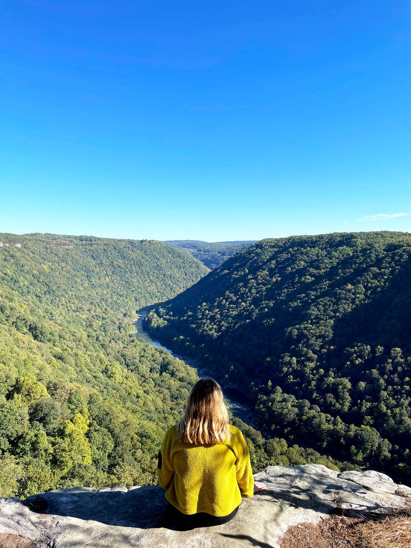 Lydia sitting on the edge of a rock at the Endless Wall trail.