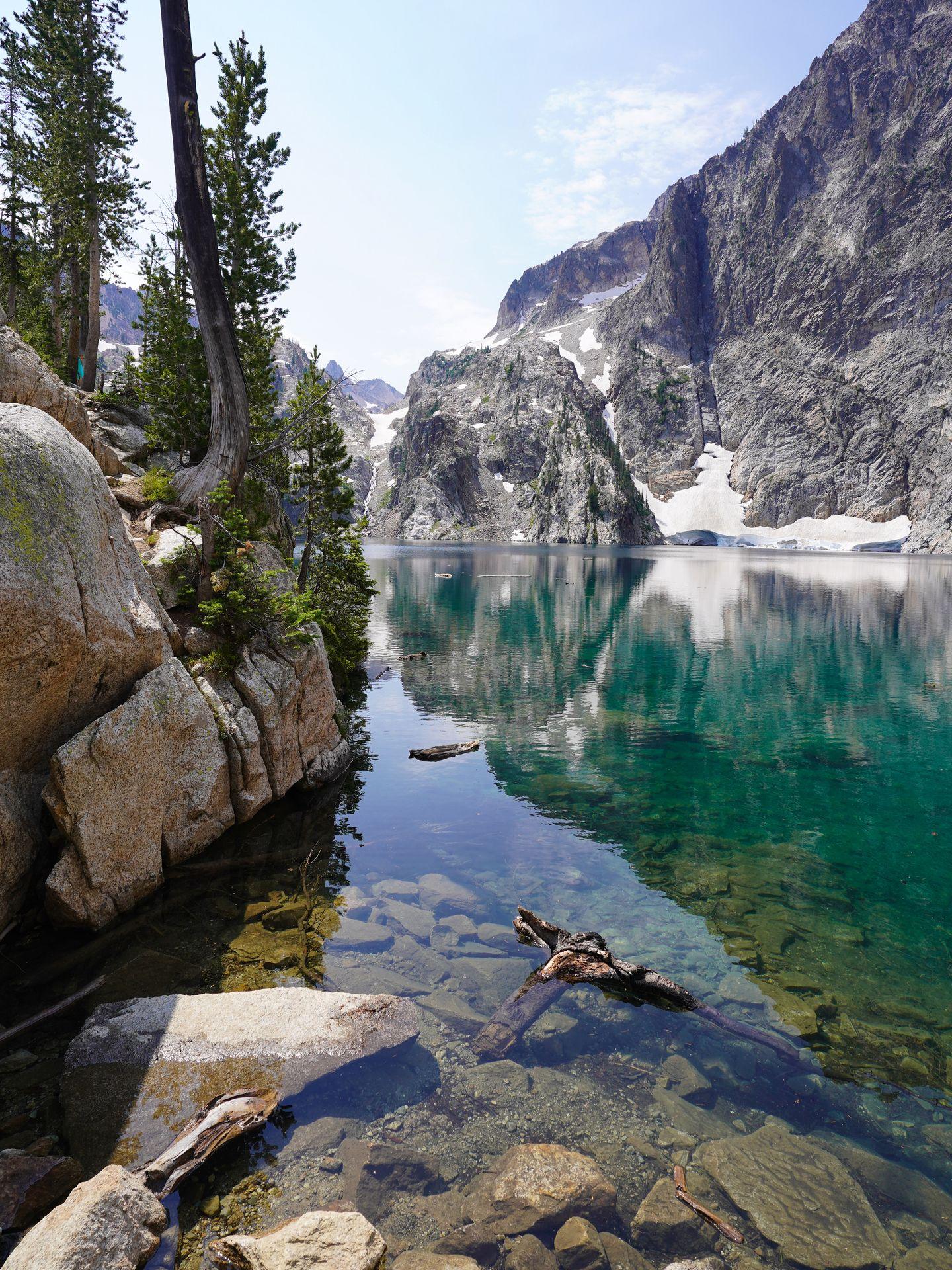 A bright blue lake with a mountain across the water.