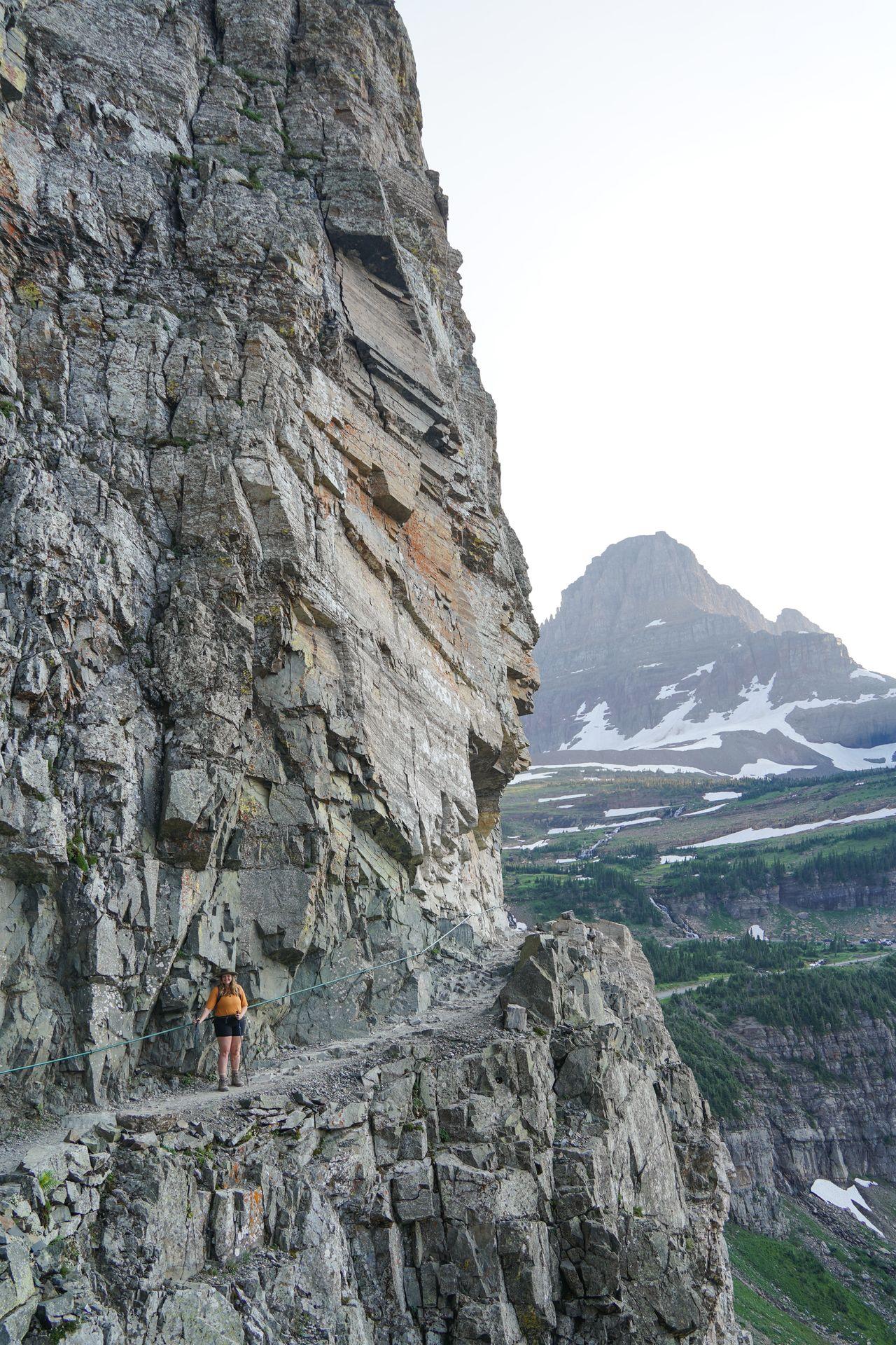 Lydia standing on a narrow ledge on the Highline Trail in Glacier National Park