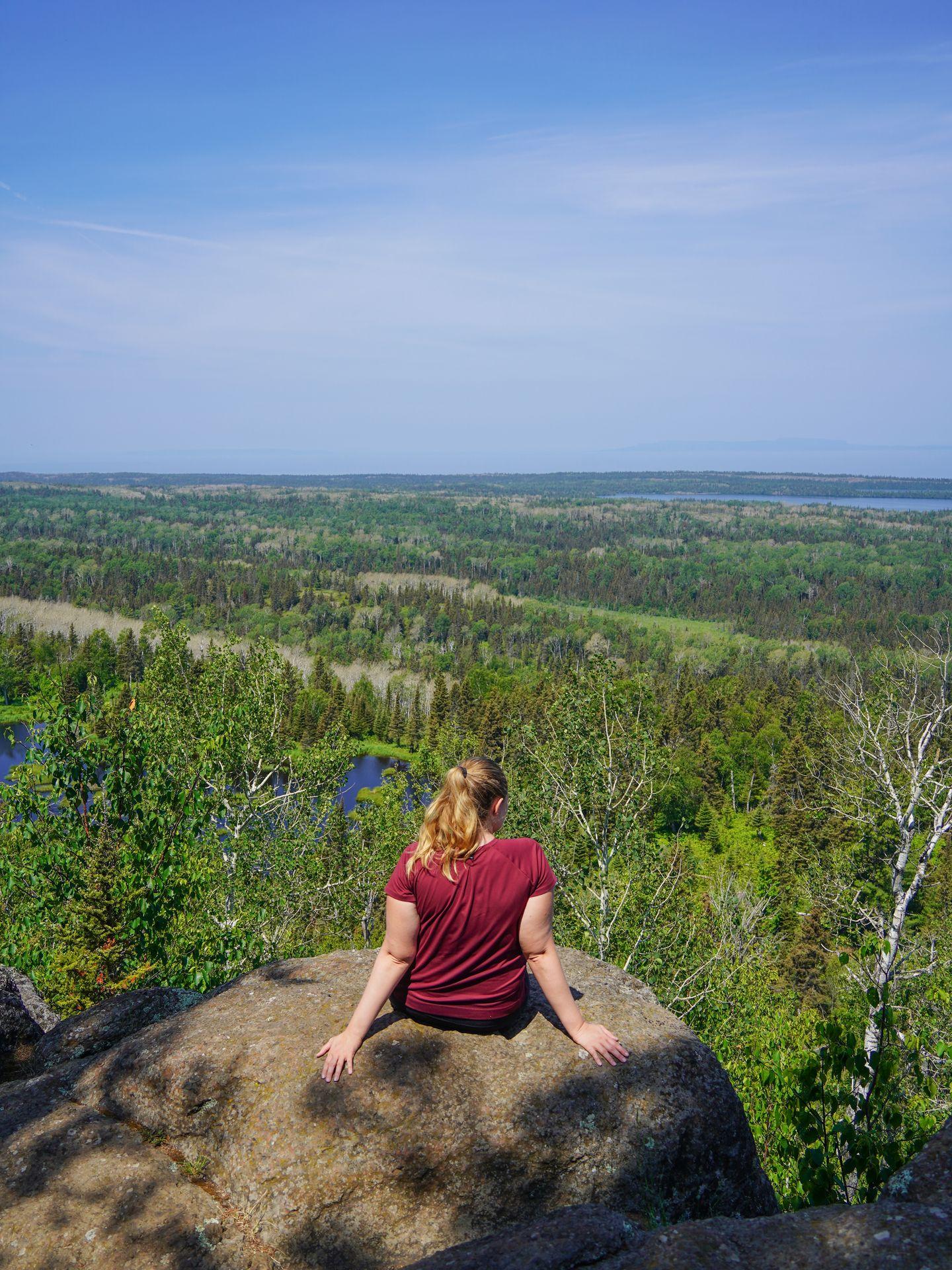 Lydia sitting and looking at the views from Mount Franklin in Isle Royale National Park