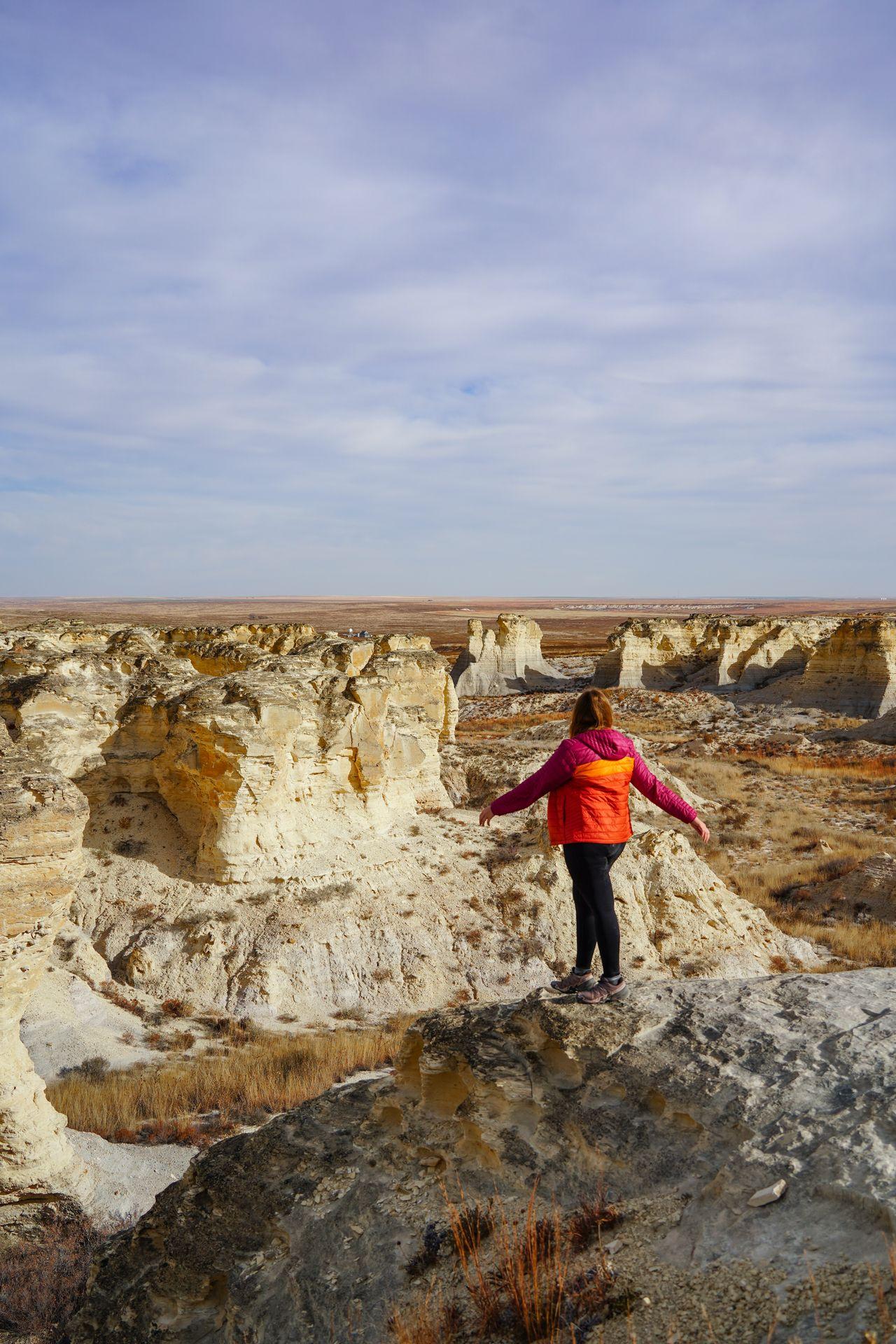 Lydia standing and looking out at the badlands on the Life on the Rocks Trail