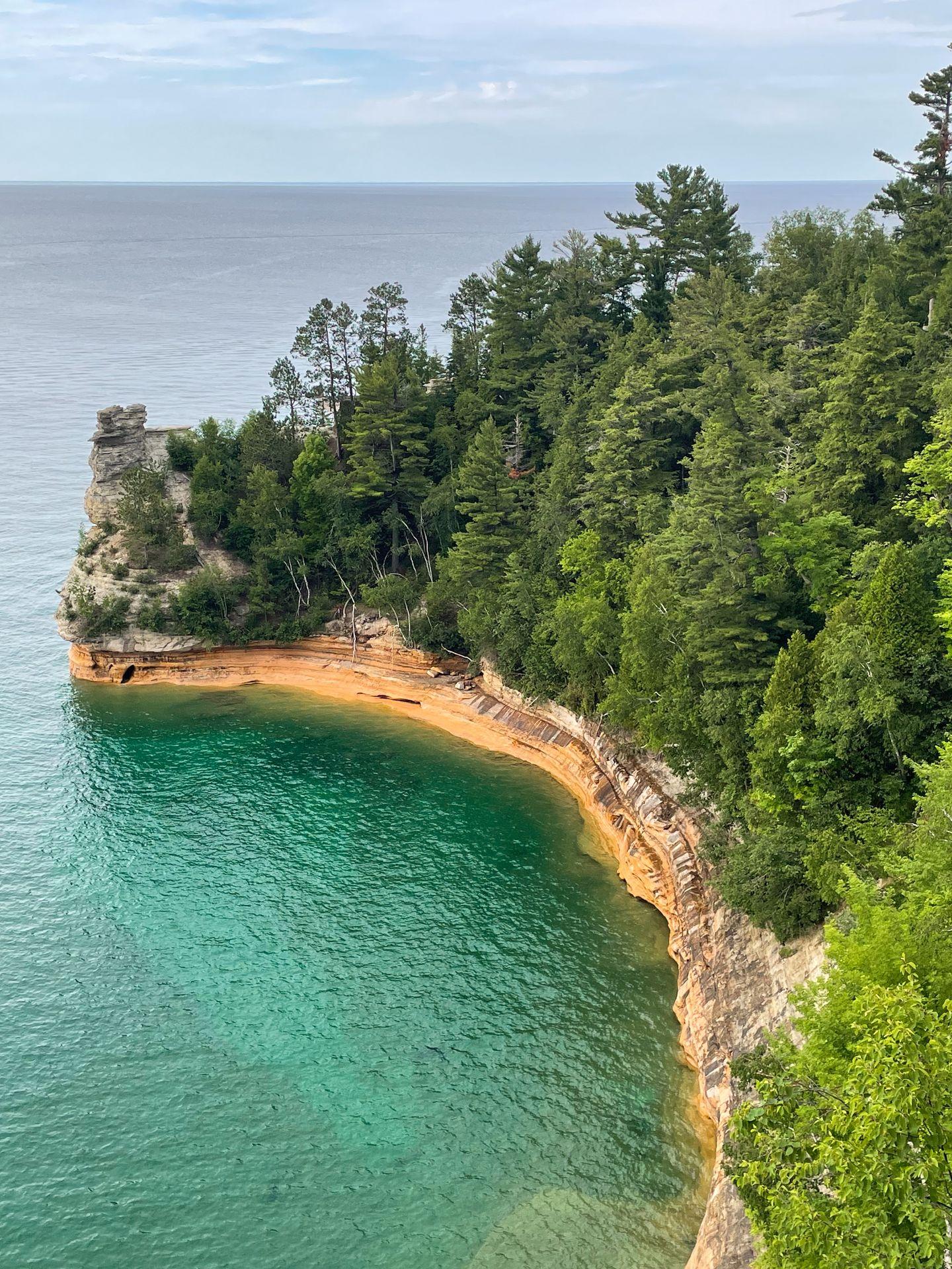 Looking at a bit of land that sticks out in the lake and has a rock that resembles a castle