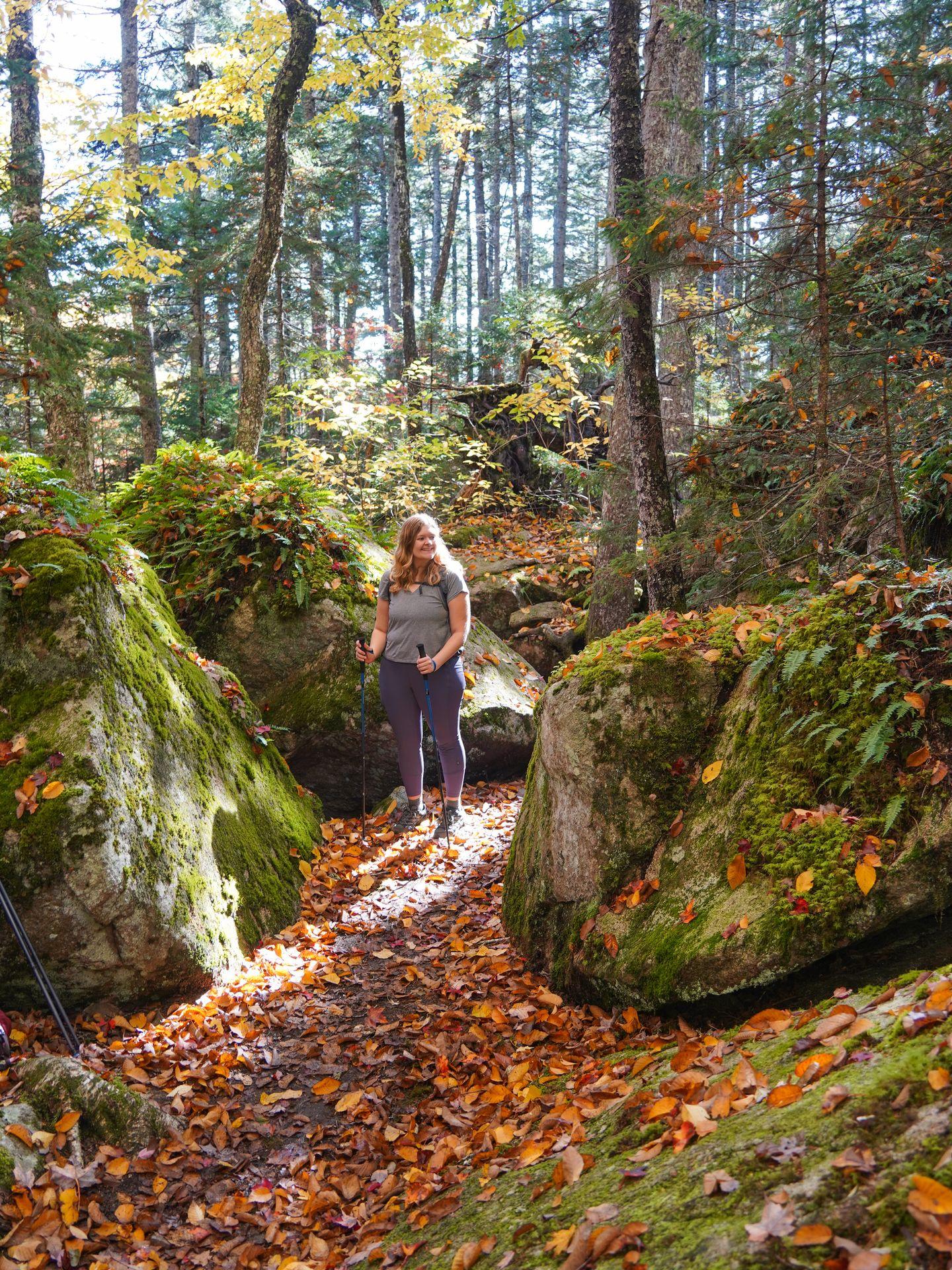 Lydia standing on the Beech Mountain South Ridge Loop trail surrounded by moss-covered boulders.