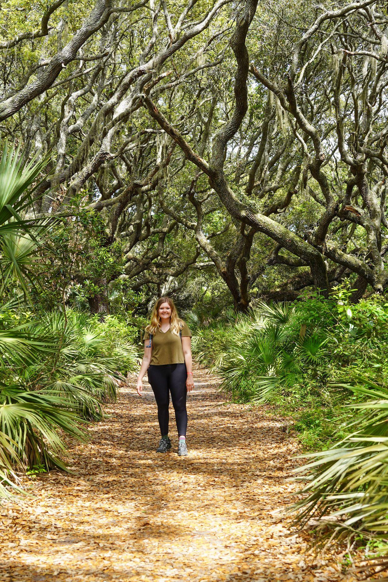 Lydia hiking on a path surrounded by palmetto trees on Cumberland Island National Seashore