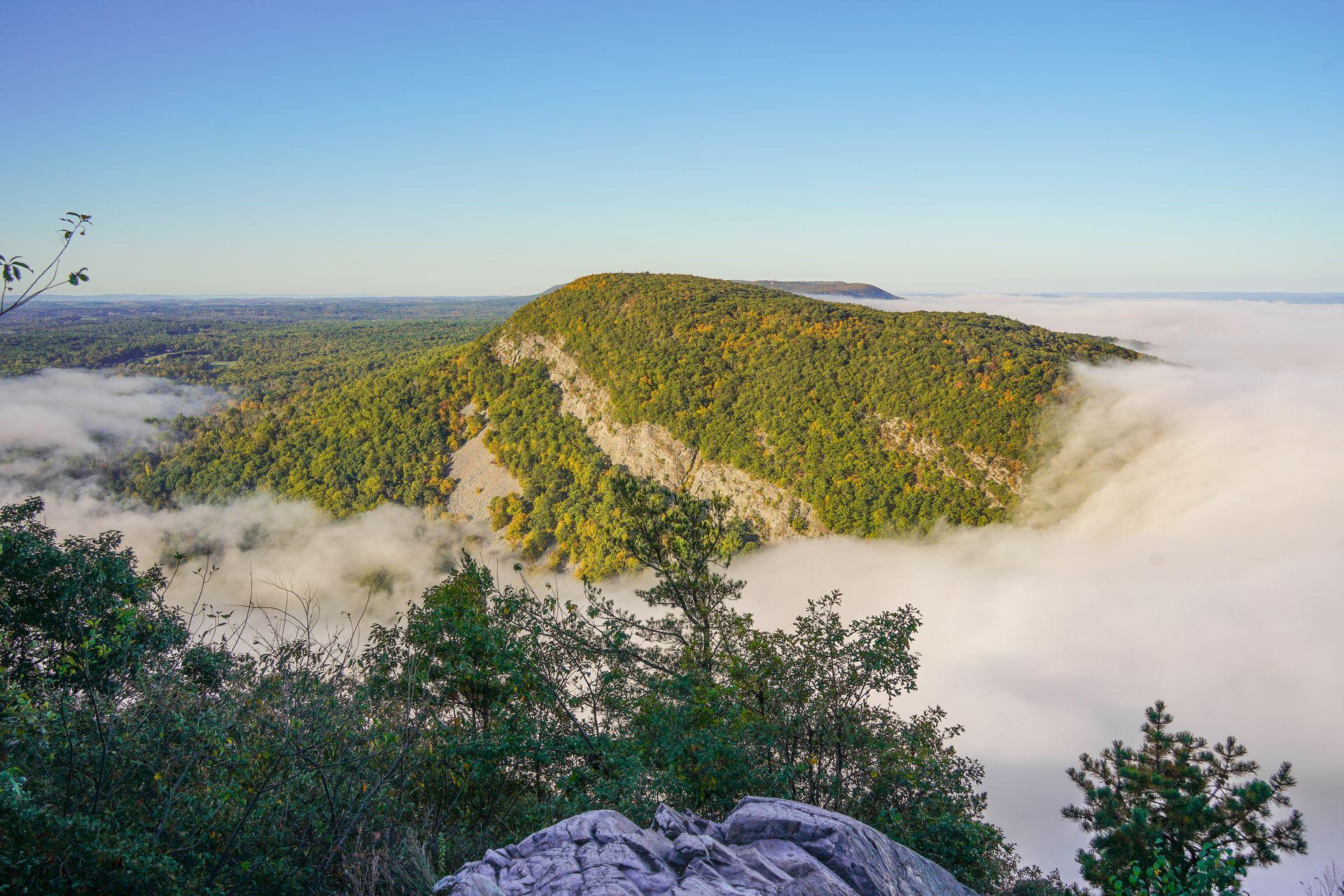 The view of a mountain partially covered in clouds from the top of Mt Tammany in New Jersey