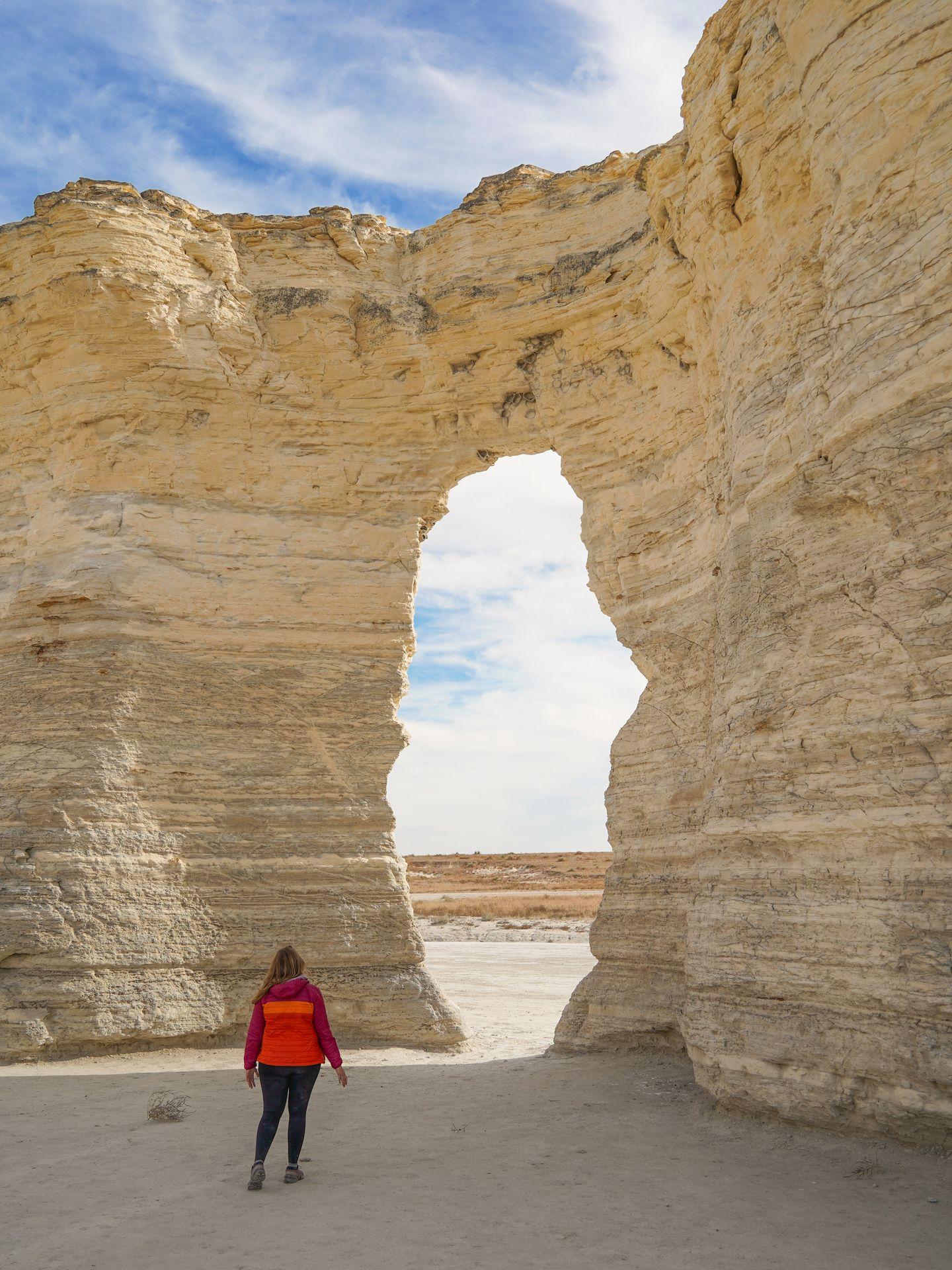 Lydia standing next to an arch through the Monument Rocks