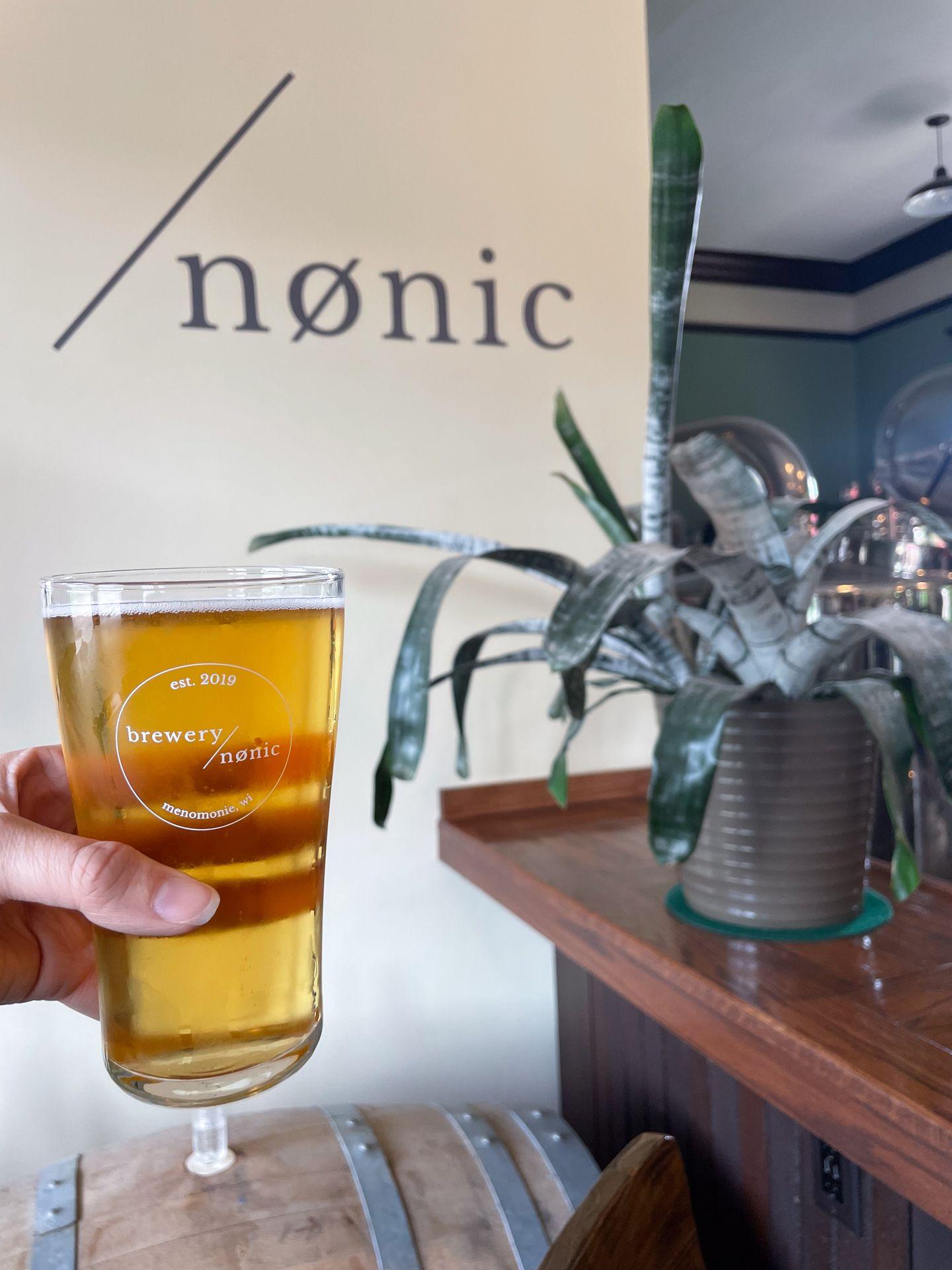 Holding up a glass of beer at brewery nønic in Wisconsin