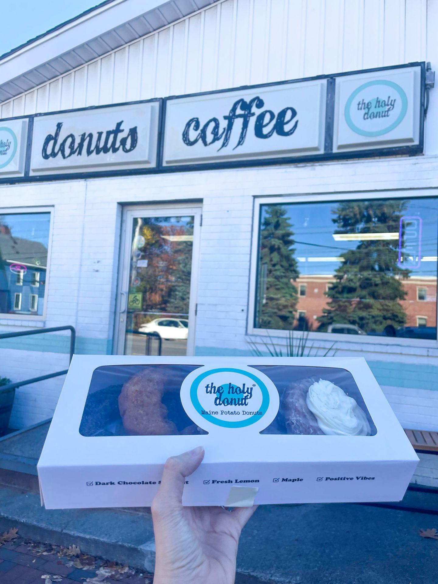 Holding up a box of donuts outside of The Holy Donut in Portland, Maine