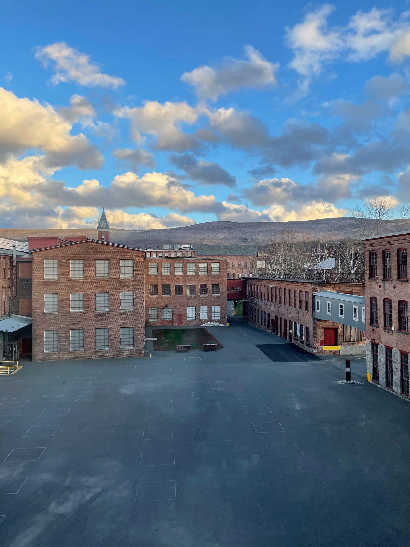 Looking out the window at the industrial campus at MASS Moca. There are several brick buildings and an open courtyard.