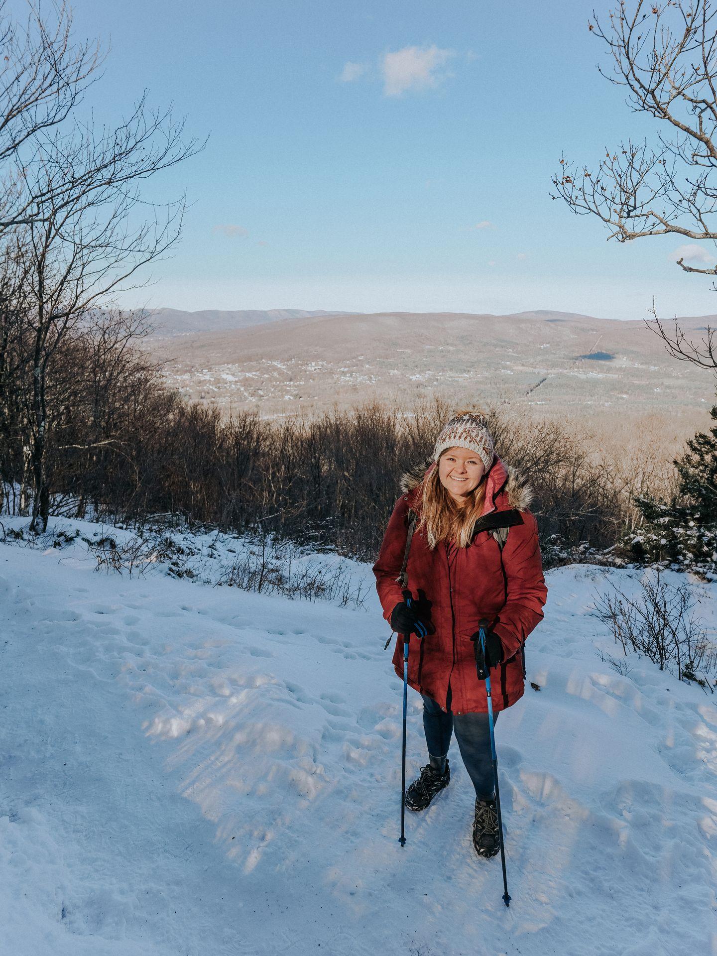 Lydia standing on snow in front of a view of a valley