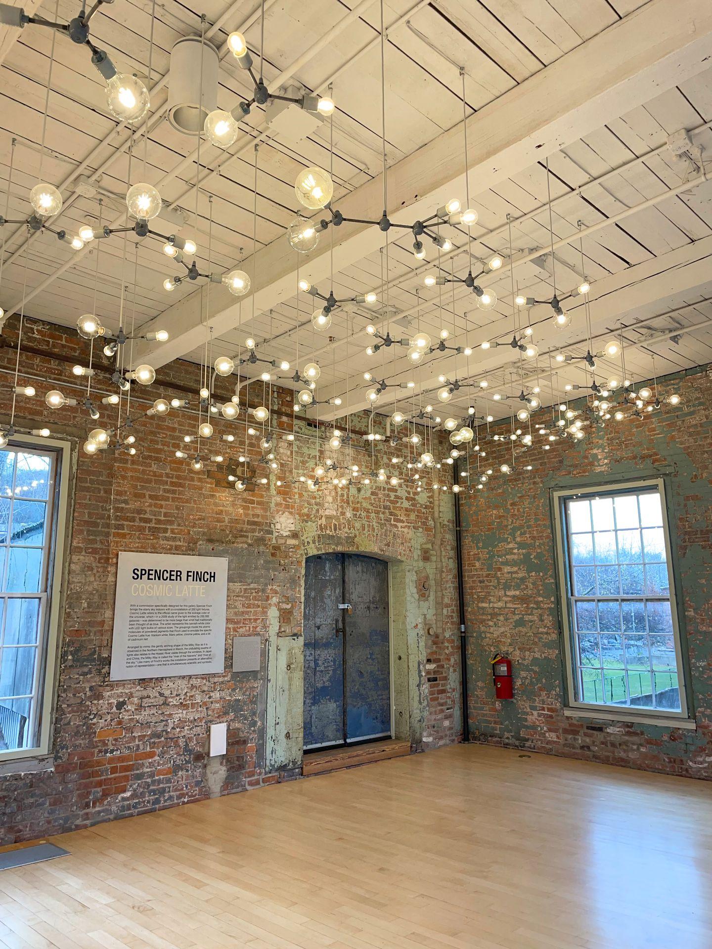 Light hanging from the ceiling in an industrial space at MASS MoCA