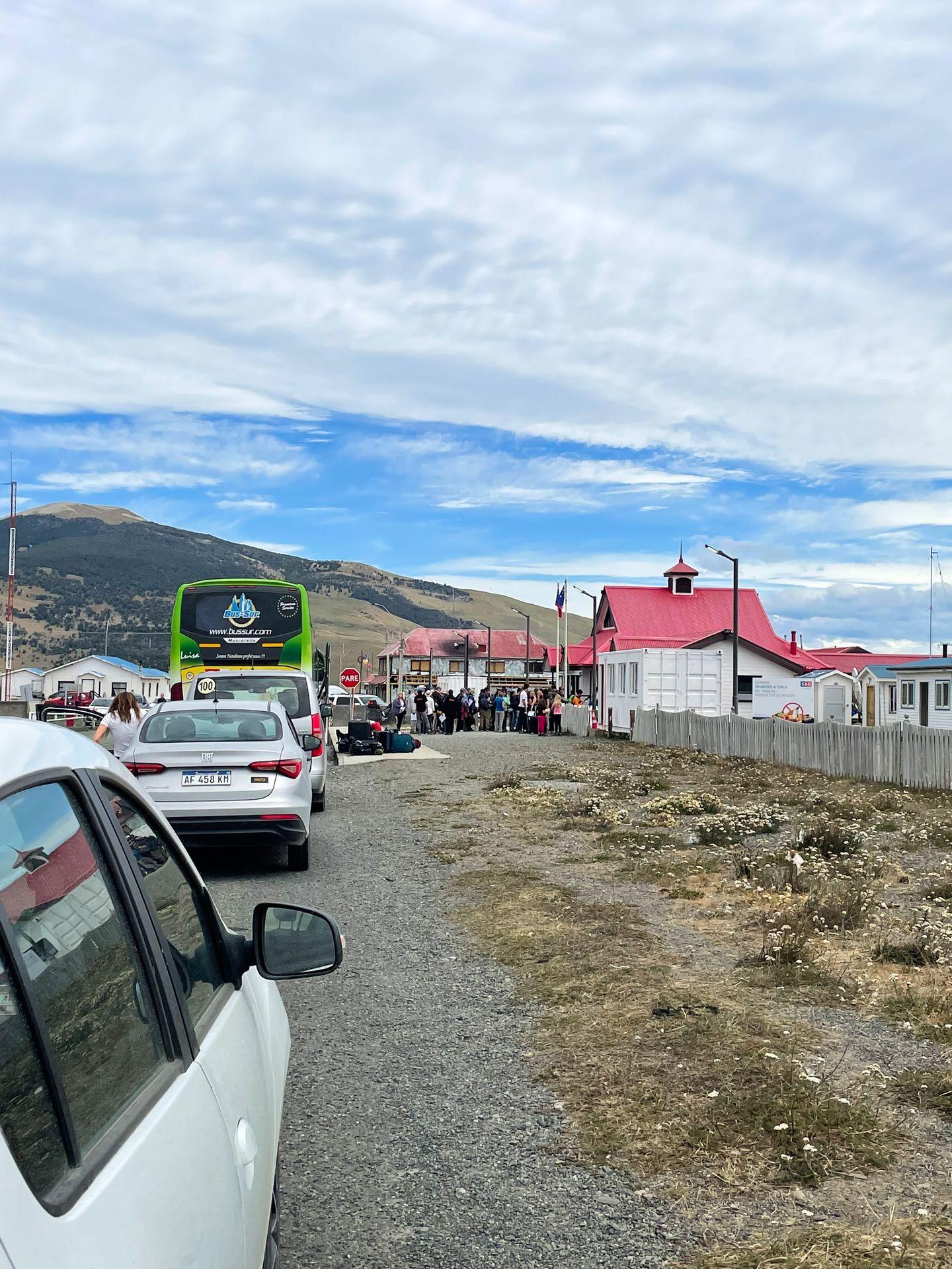 A line of cars and a bus outside of the border crossing to enter Chile.