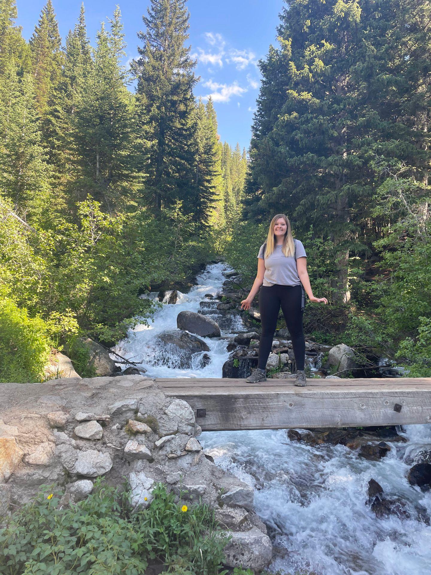 Lydia standing on the bridge that crosses White Pine Fork River on the Gloria Falls trail.