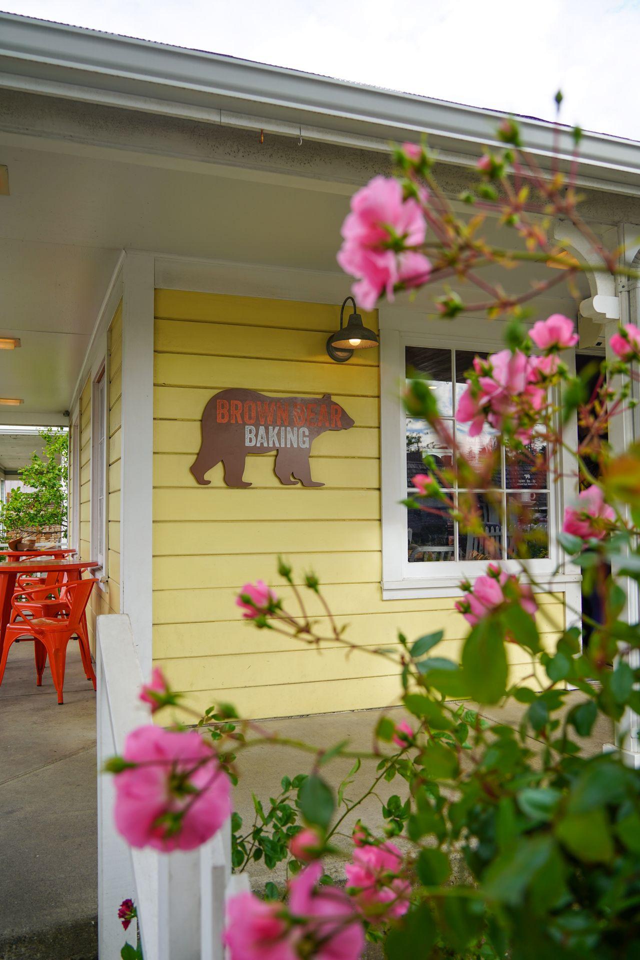 Pink flowers in front of the outside of Brown Bear Baking