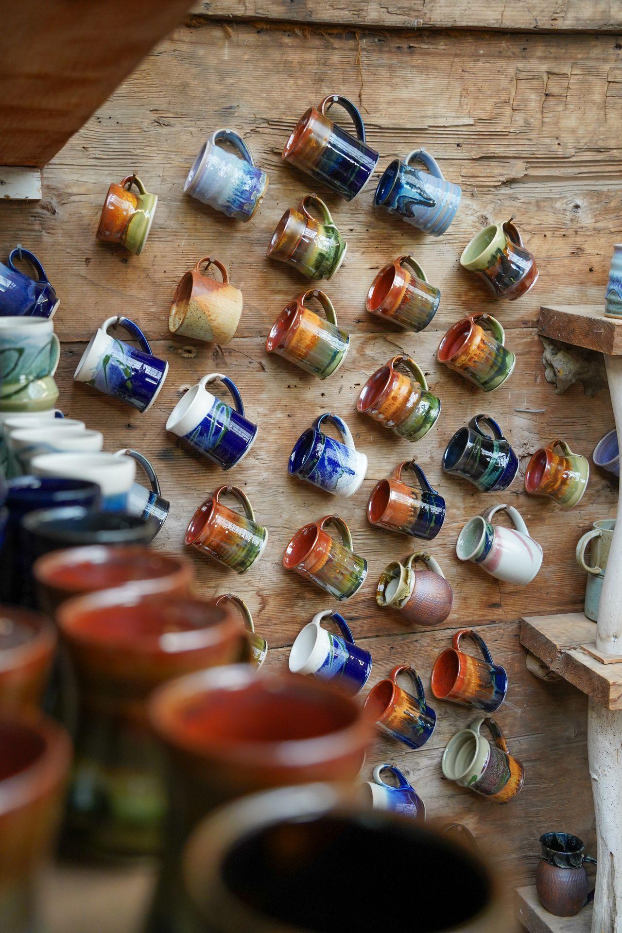 A wall with several hanging mugs at Orcas Island Pottery