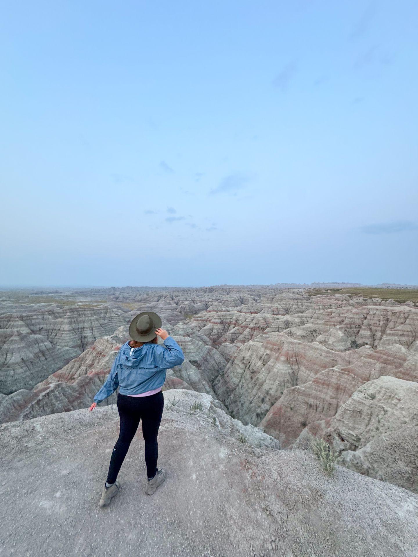 Lydia standing on rocks and looking out at the Big Badlands Overlook.