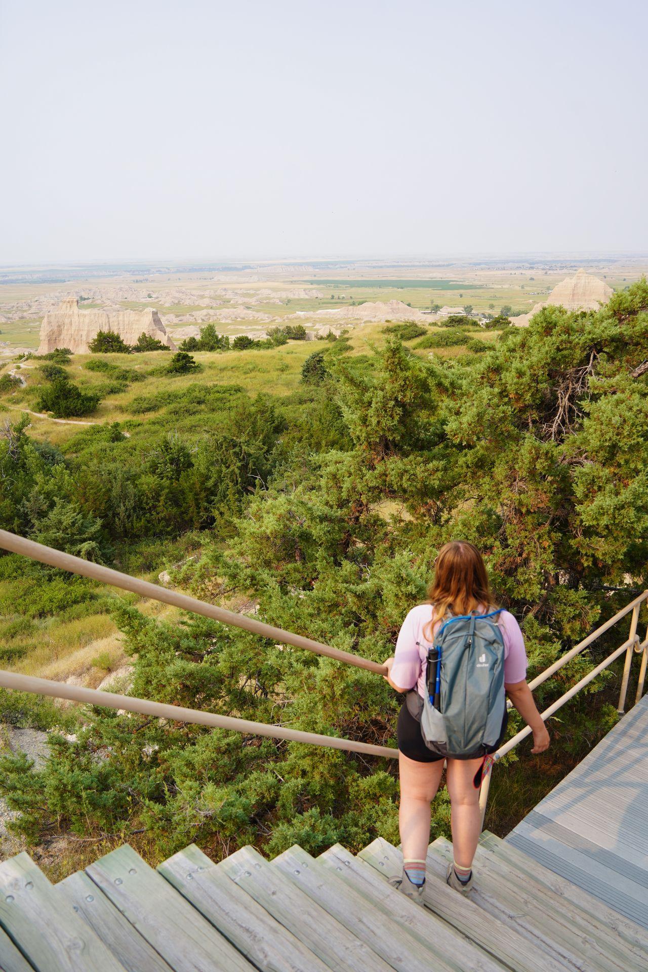 Lydia walking down steps and looking out a view on the Cliff Shelf Nature Trail in Badlands National Park