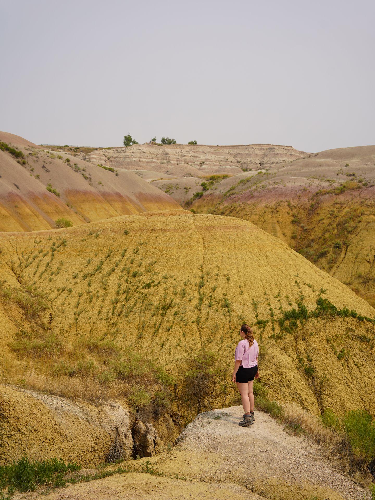 Lydia standing in front of round, yellow mounds at the Yellow Mounds Overlook