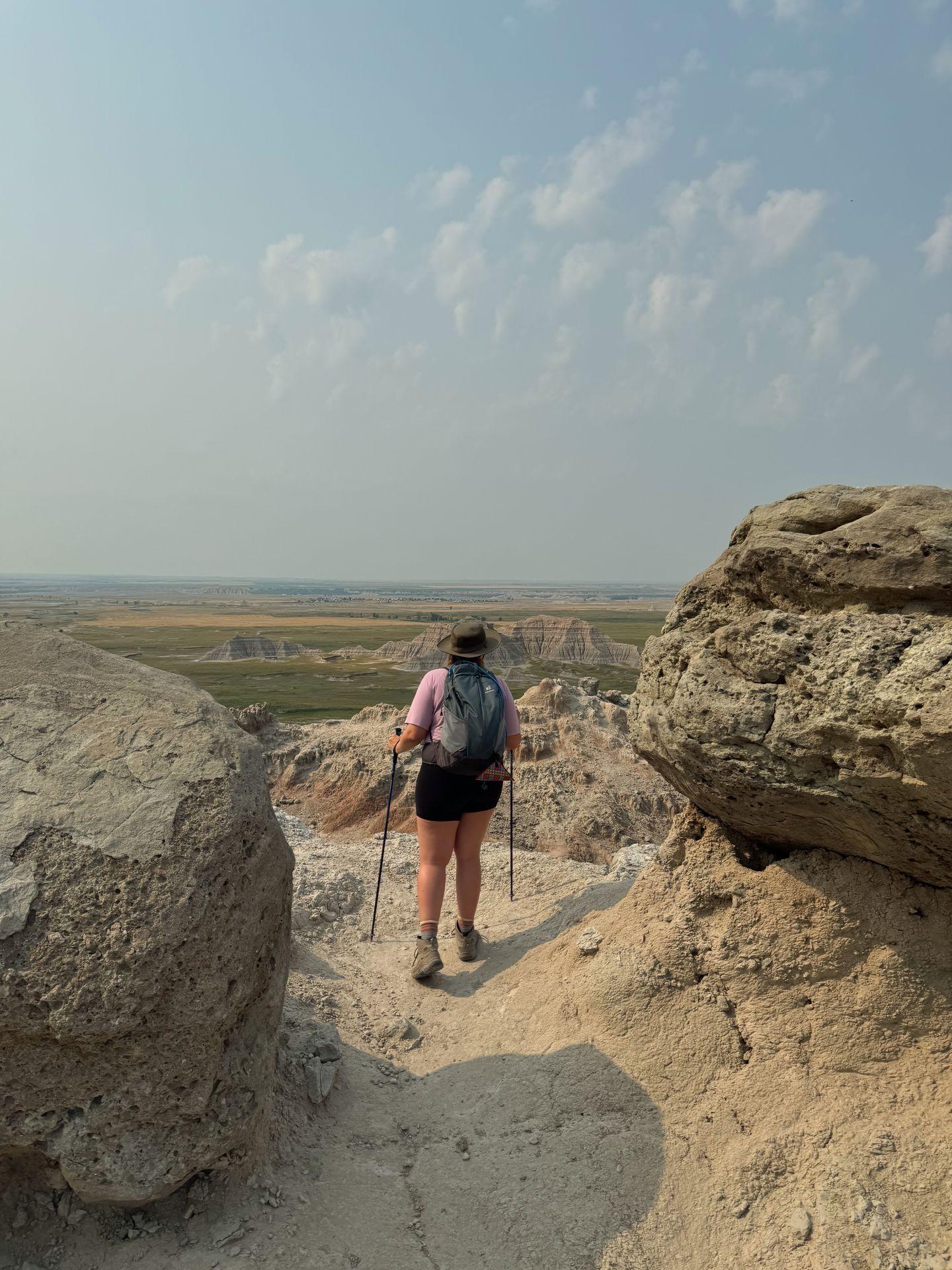 Lydia standing between large boulders at the top of Saddle Pass