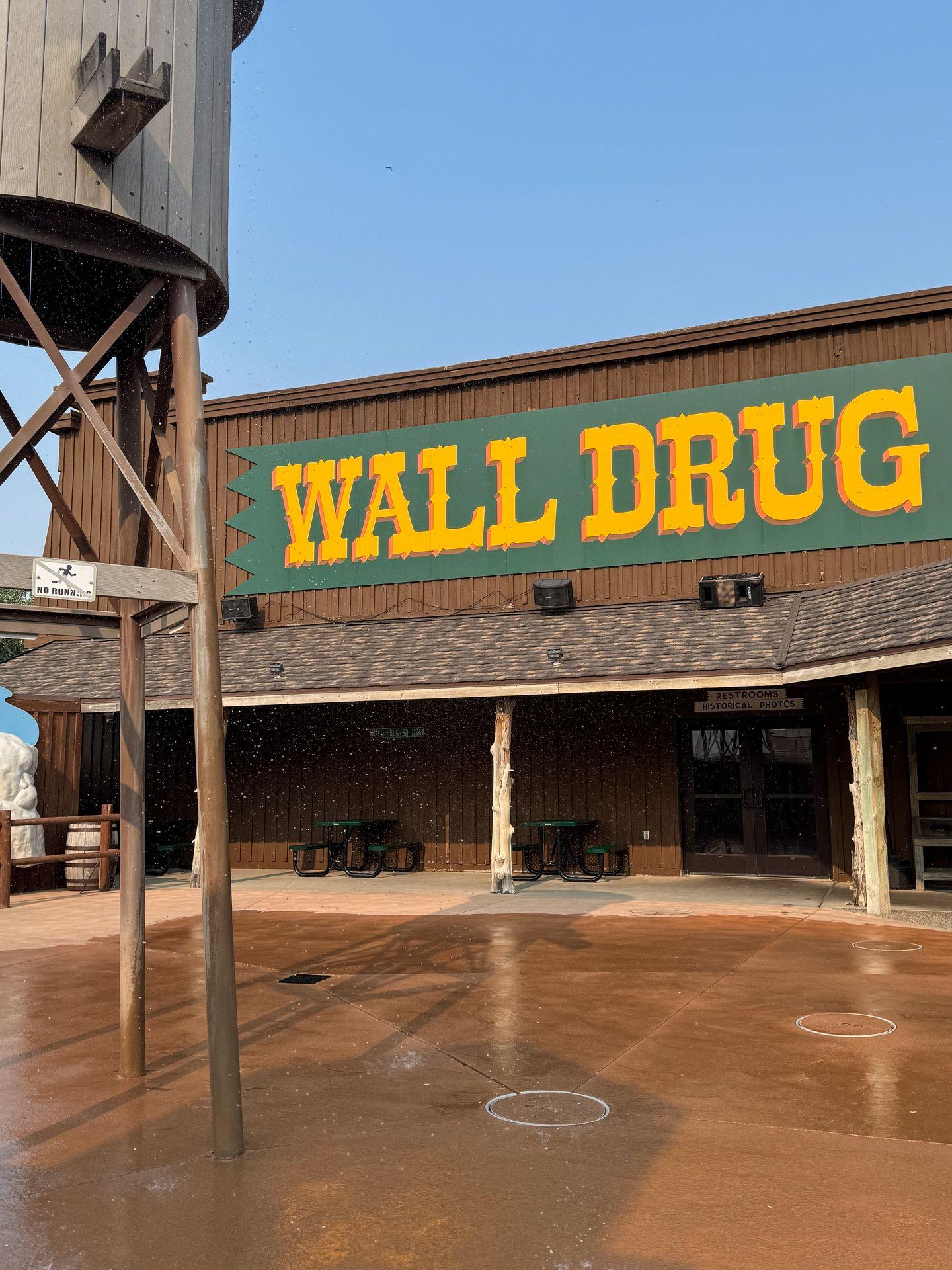 The outdoor space at Wall Drug. There is a large 'Wall Drug' sign and a water tower