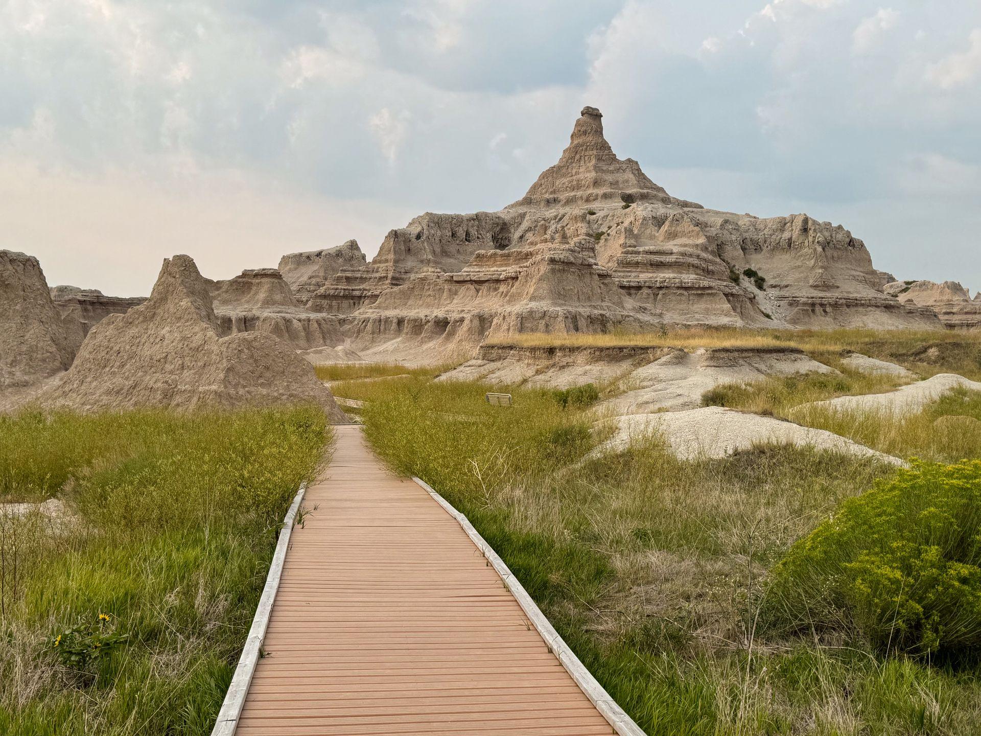 A flat boardwalk leading next to jagged badlands rocks on The Window Trail in Badlands National Park