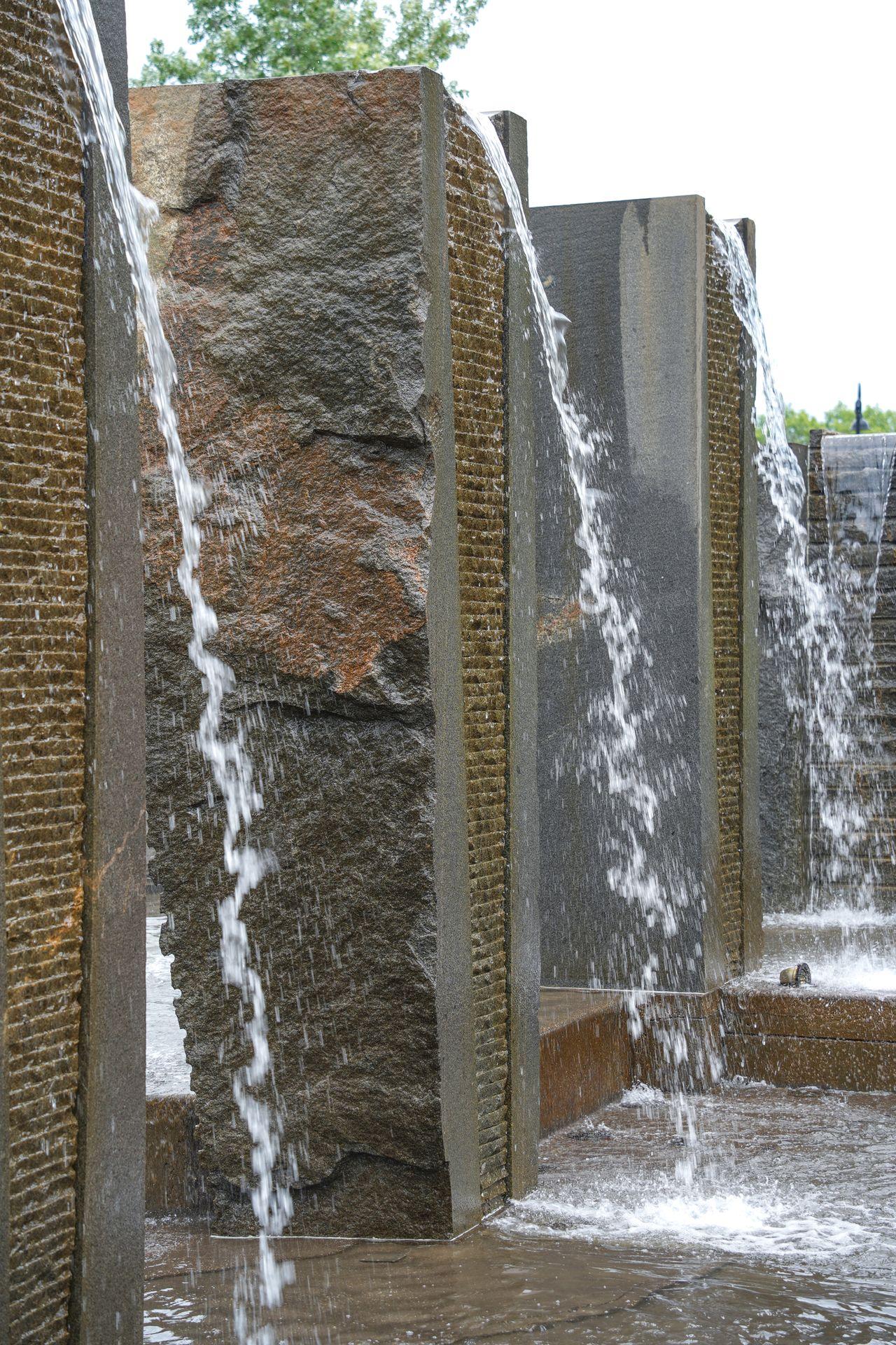Water falling from a stone wall at the Granite Fountain along Lake George