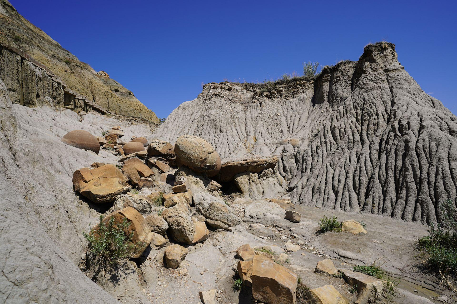 Round, yellow rocks sticking out of badland formations at the Cannonball Concretions Pullout