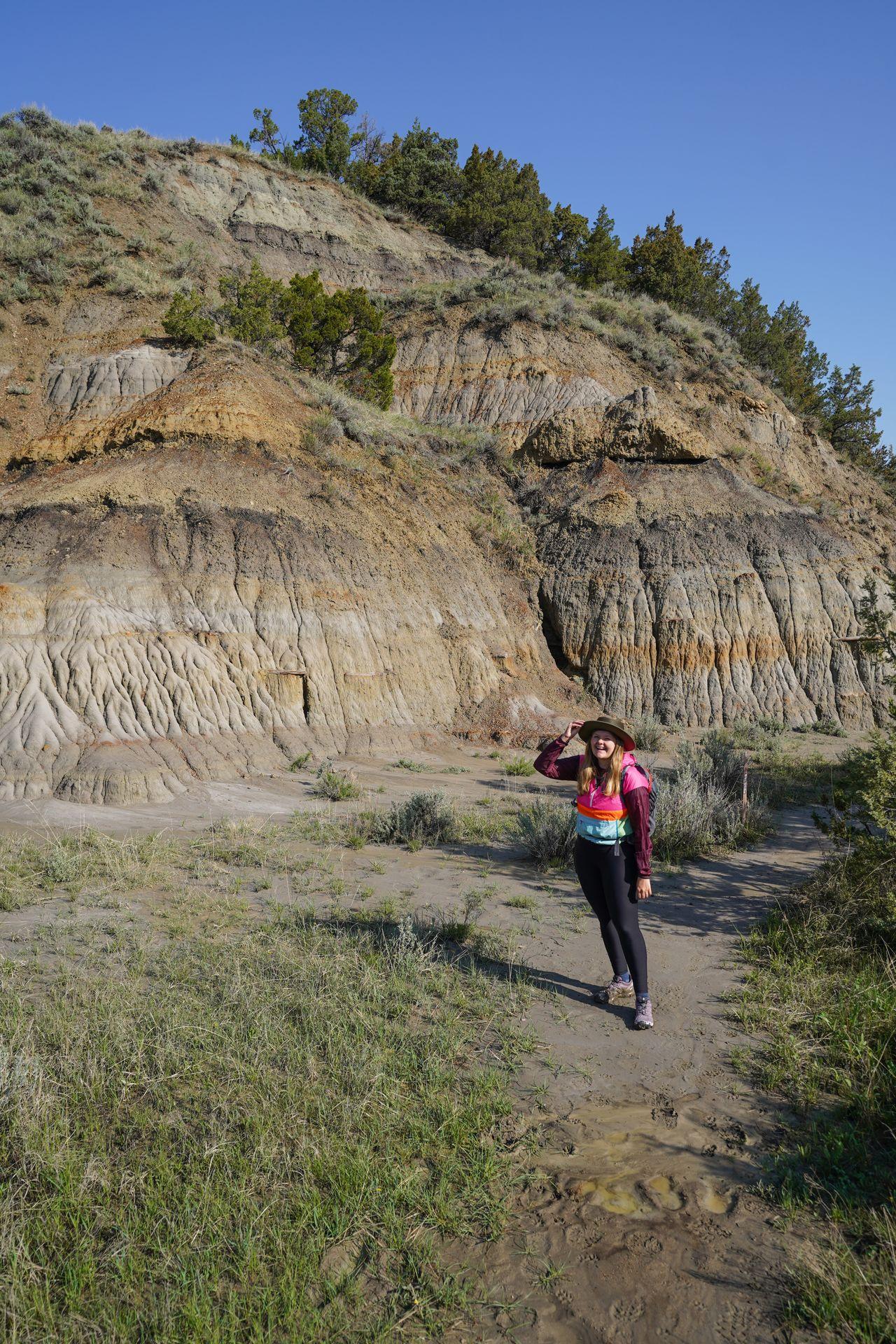 Lydia standing in front of some colorful rocks on the Caprock Coulee Trail