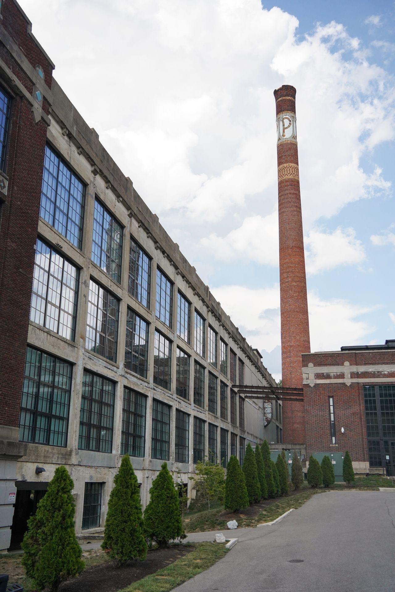 An industrial building with a tall smokestack.