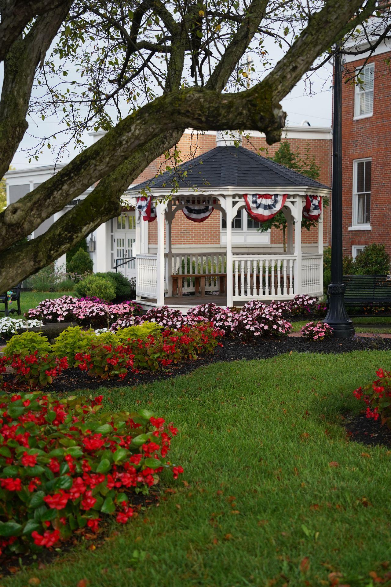 A white gazebo surrounded by flowers in downtown Lebanon