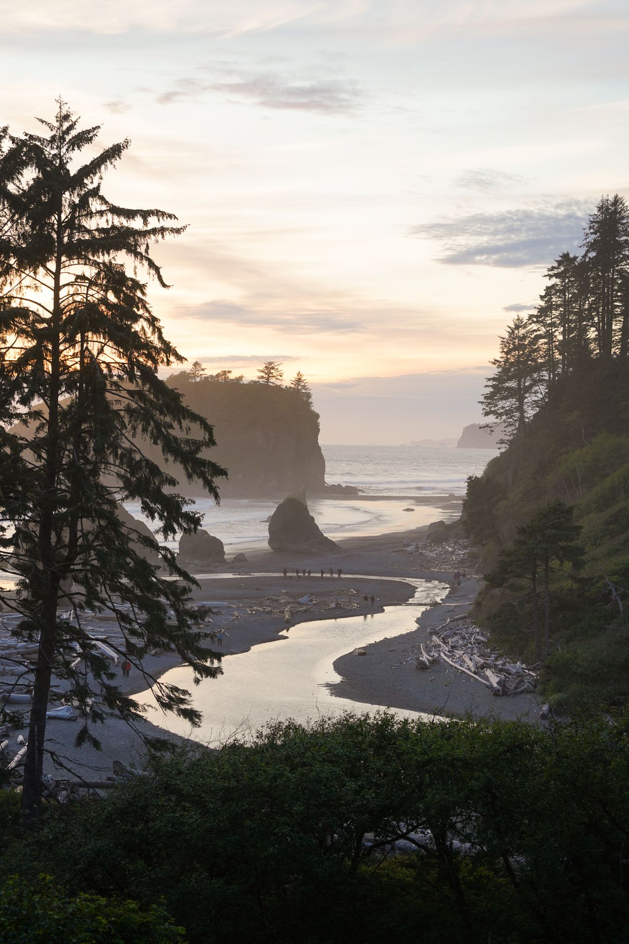 Looking down at Ruby Beach at sunset. There are large rock formations and a stream that cuts across the beach