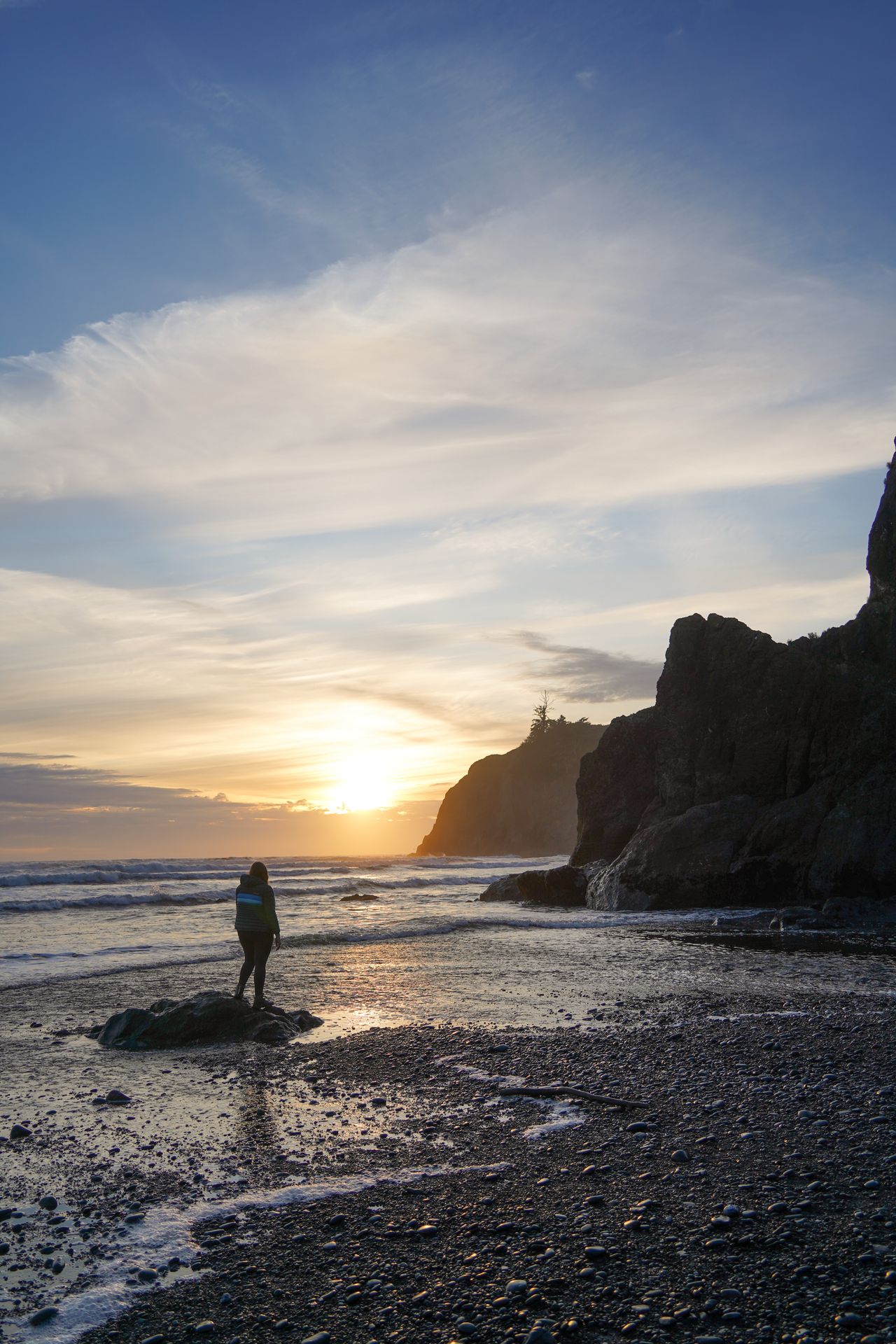 Lydia standing on a rock and watching the sunset on Ruby Beach