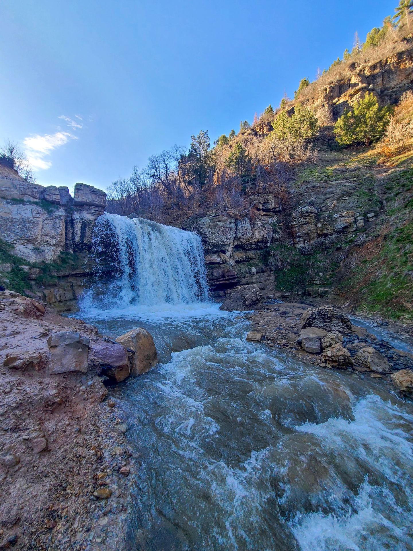A waterfall in a red canyon next to Fifth Water Hot Springs. It is flowing hard in the spring