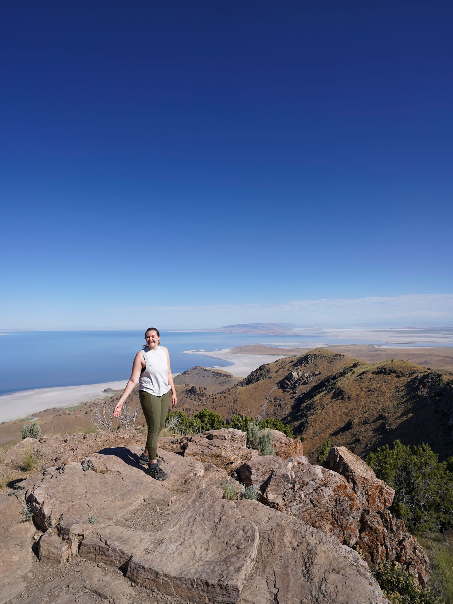Lydia standing on top of Frary Peak with a view of the Great Salt Lake in the distance.